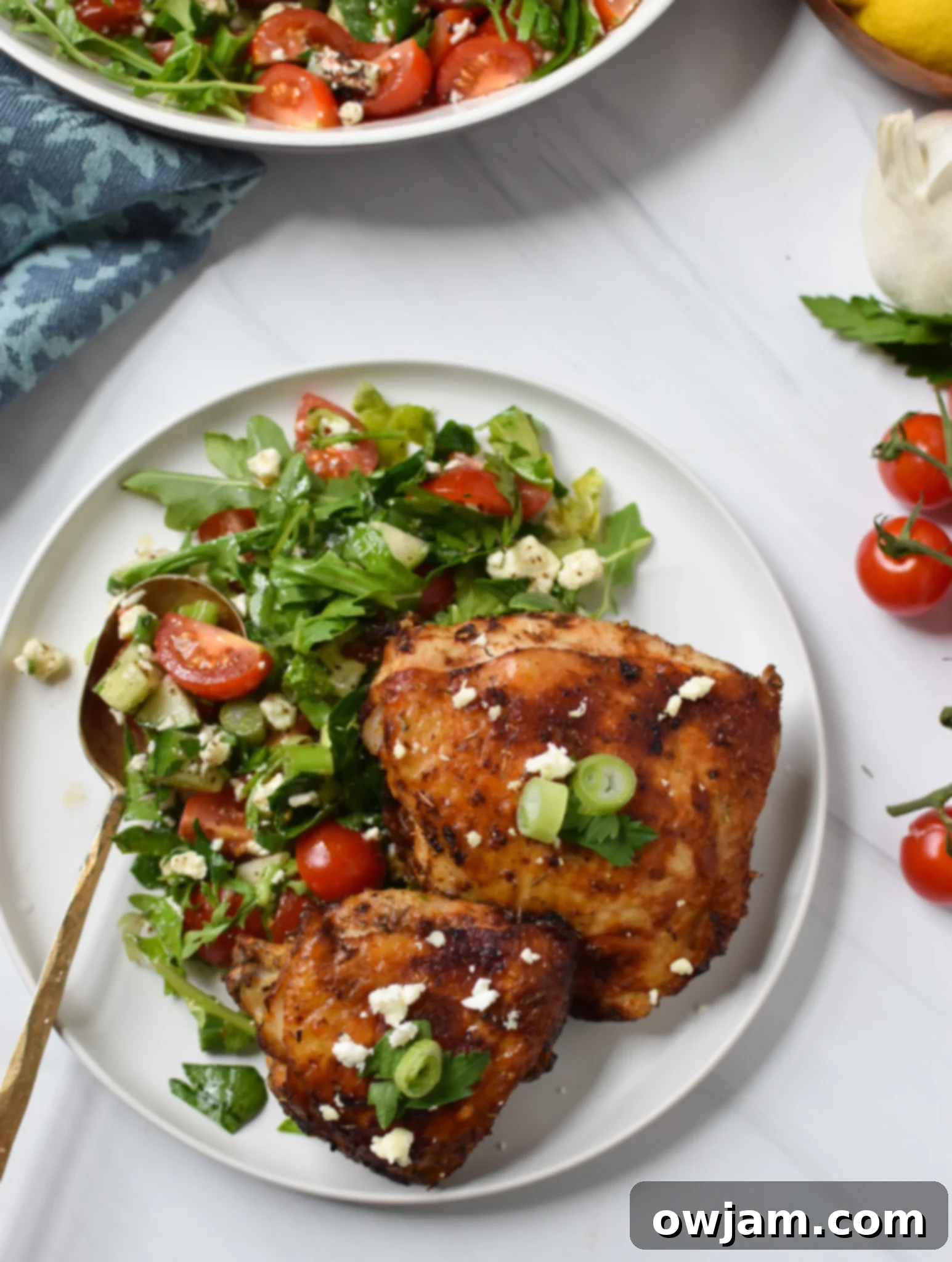 Air Fryer Mediterranean Chicken Thighs served with a spoon and fresh herbs.