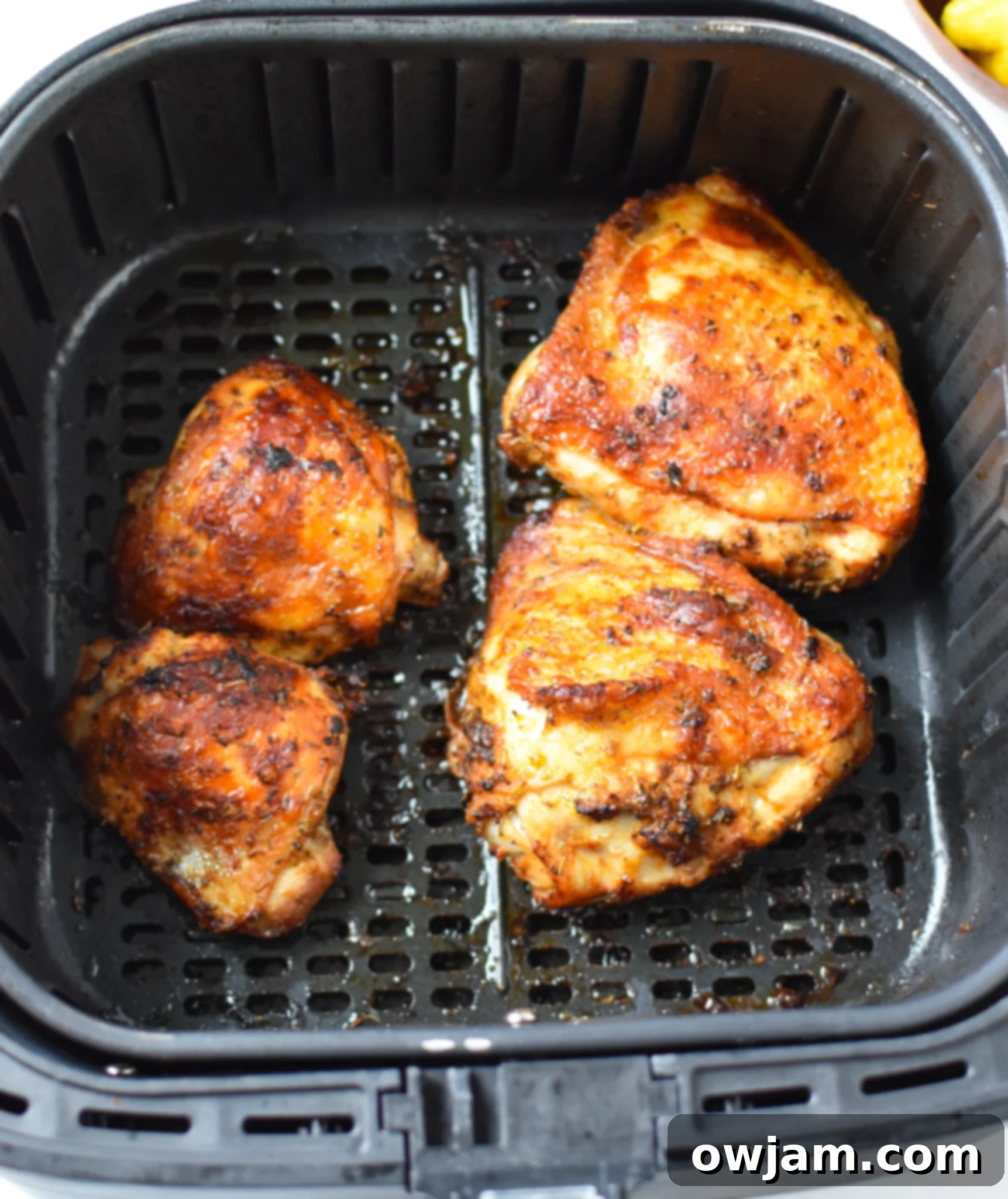 Air Fryer Mediterranean Chicken Thighs removed from the air fryer, showing crispy skin.