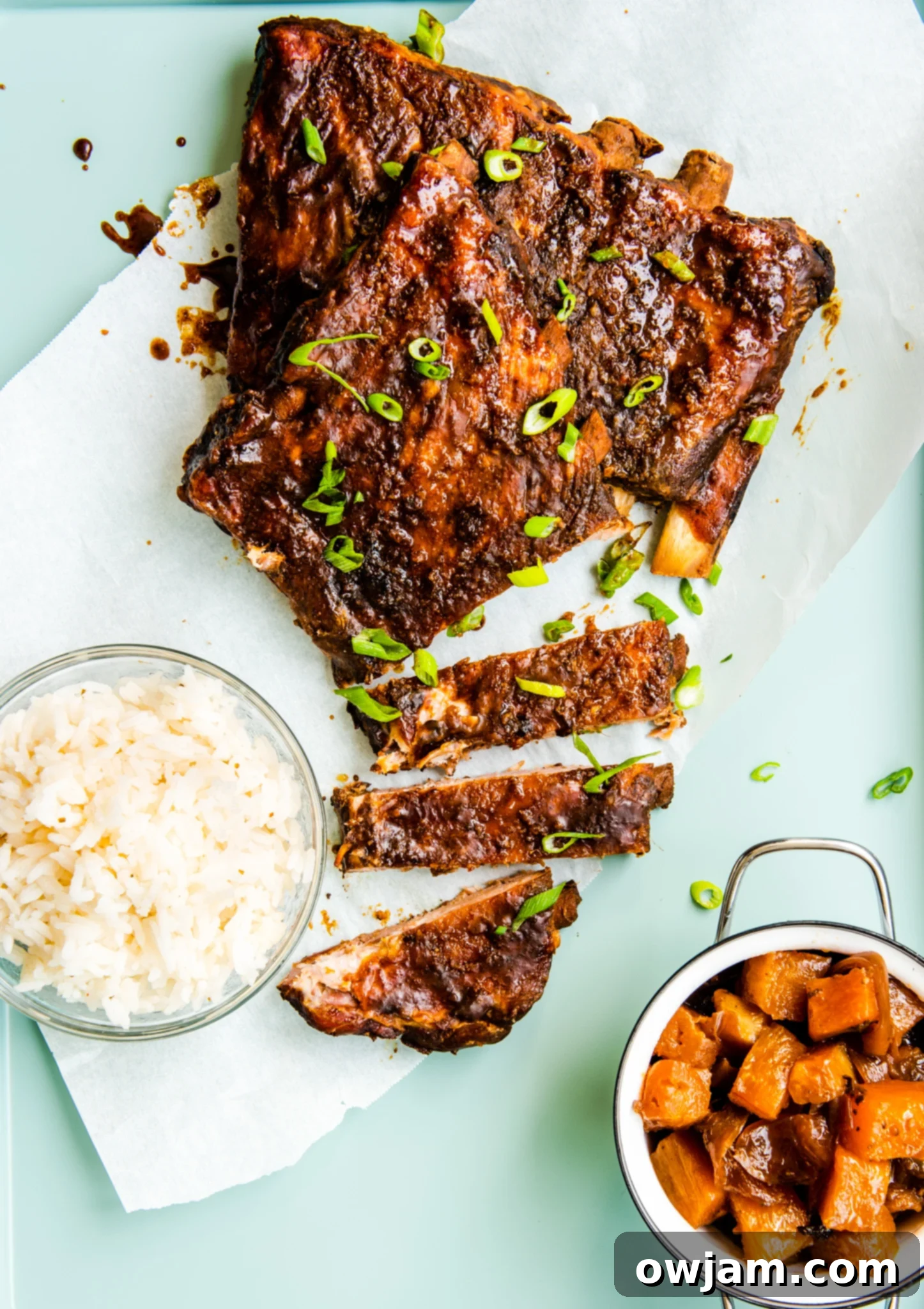 Aloha Slow Cooker Pork Ribs 9 Slow Cooker Hawaiian Pork Ribs unwrapped on parchment paper, ready to be served or broiled.