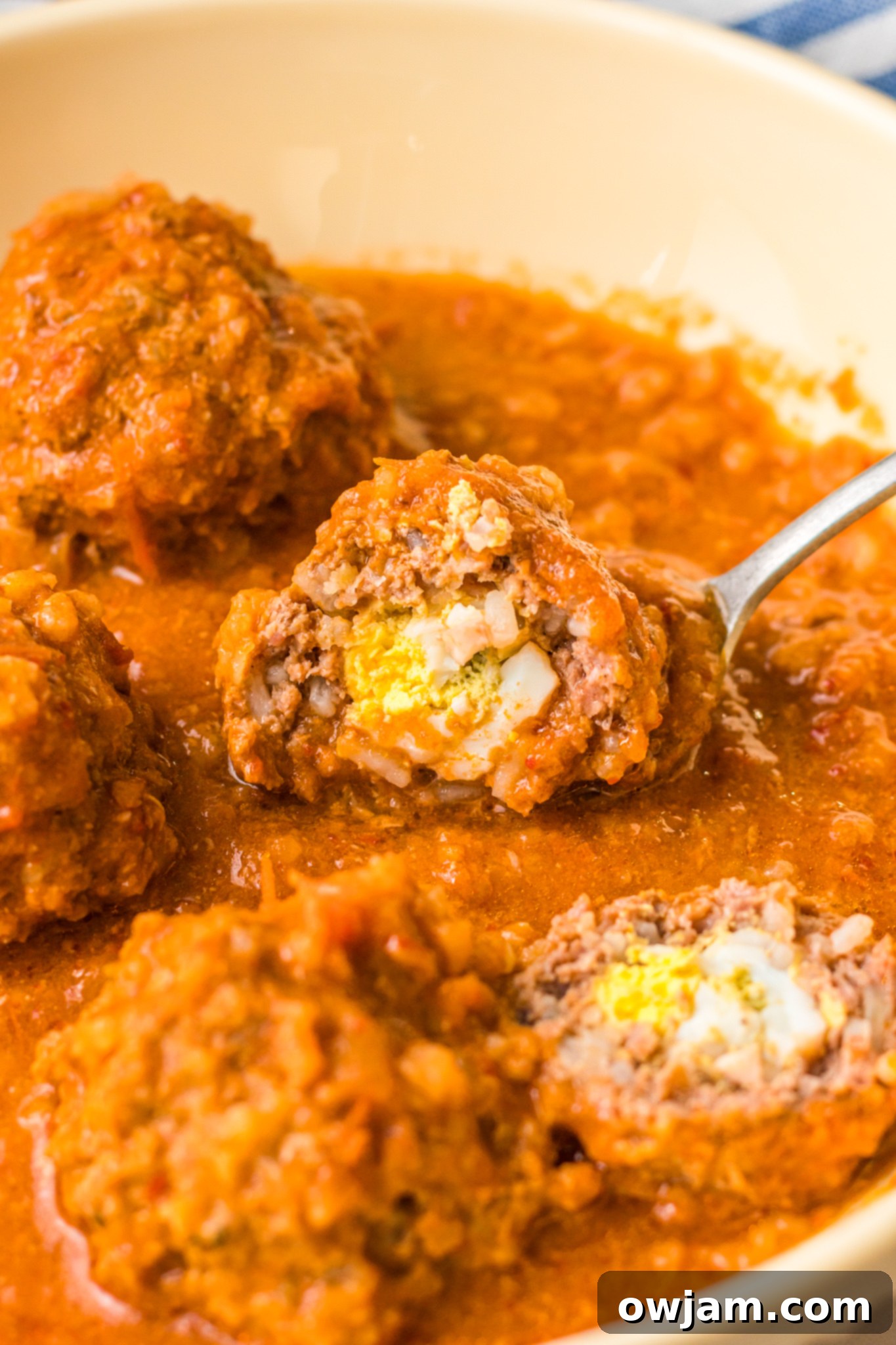 Chipotle Meatballs 12 Close-up of a perfectly cooked Albondigas en Chipotle, cut in half to showcase the delightful hard-boiled egg surprise inside.