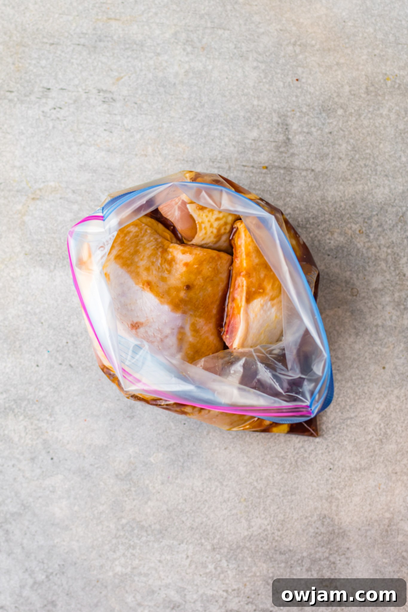 Hawaiian Fire Chicken 7 Chicken pieces marinating in Huli Huli sauce inside a sealed zip-top bag.