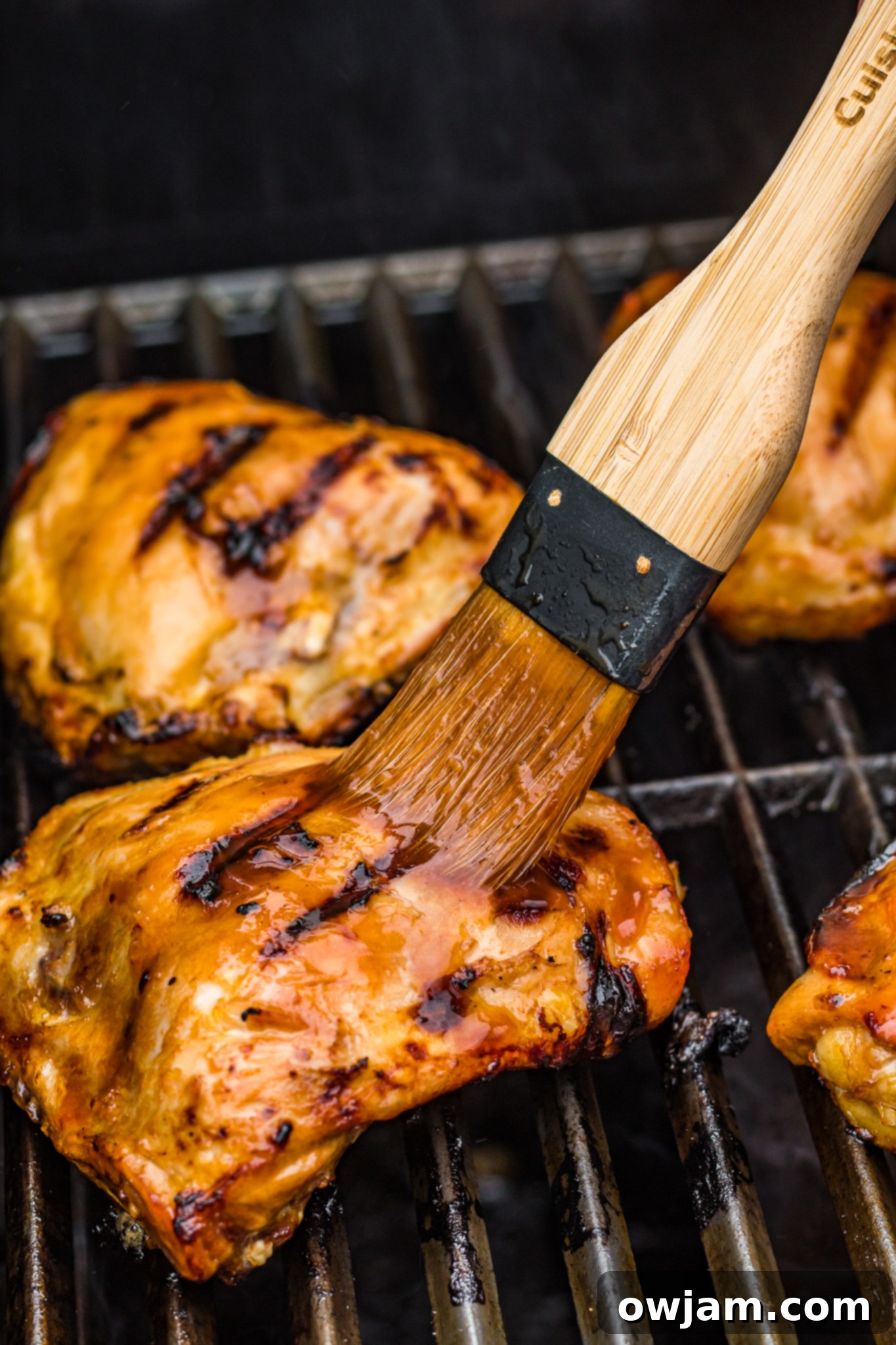 Hawaiian Fire Chicken 10 A basting brush applying the Huli Huli sauce to grilled chicken pieces.