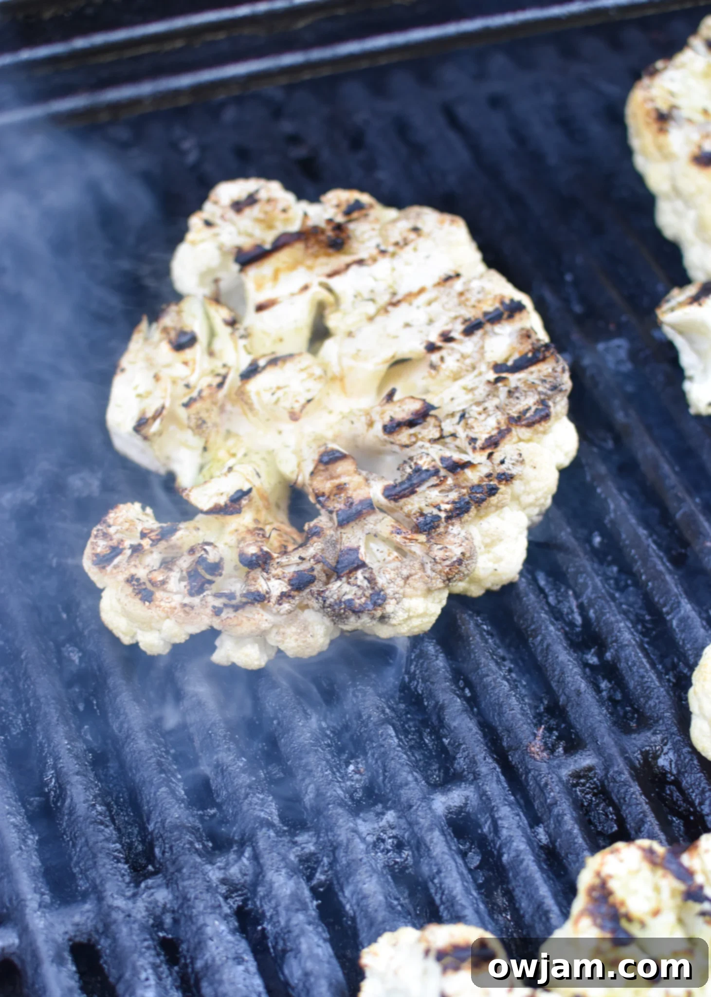 Grilled Cauliflower Steaks cooking on a hot grill.
