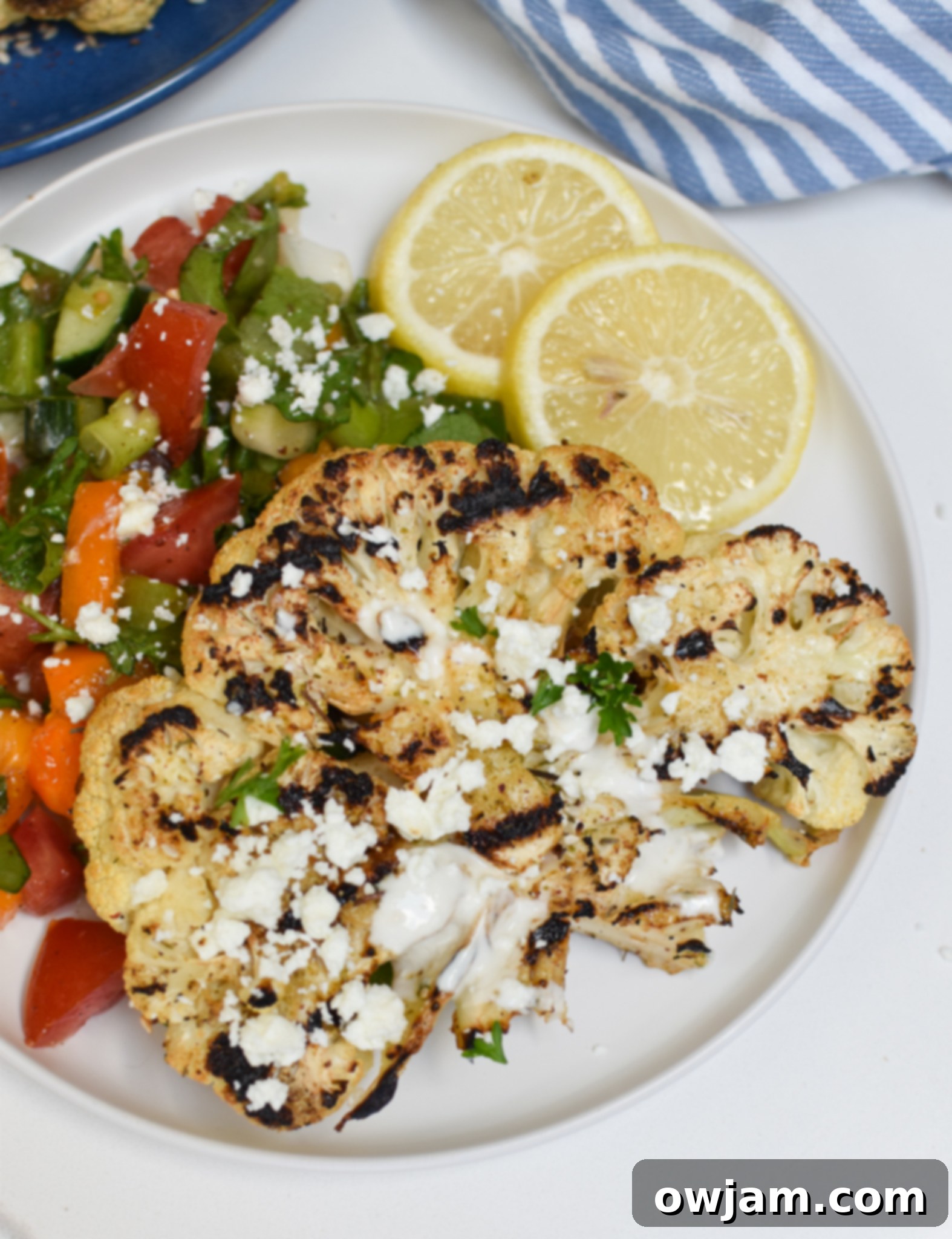 Grilled Cauliflower Steaks with Yogurt Tahini Sauce served with a fresh salad.