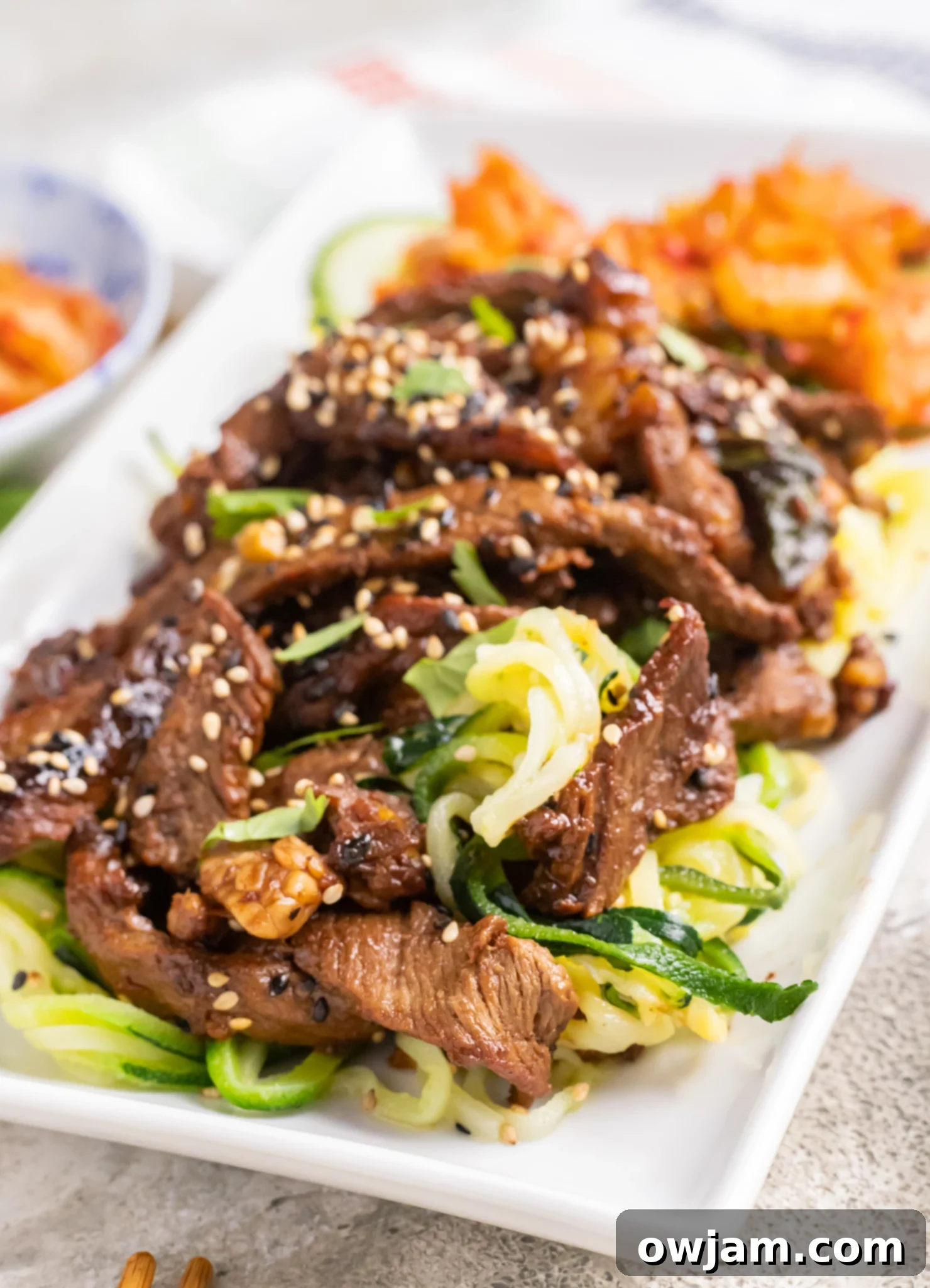 Bulgogi Zoodle Bowl 2 Beef Bulgogi with Zucchini Noodles on a white plate.