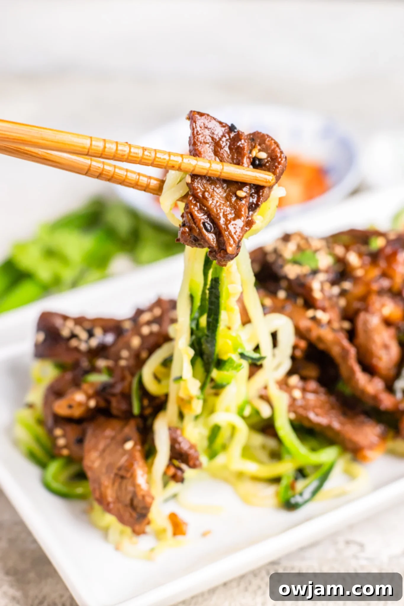 Bulgogi Zoodle Bowl 3 Beef Bulgogi with Zucchini Noodles with chopsticks.