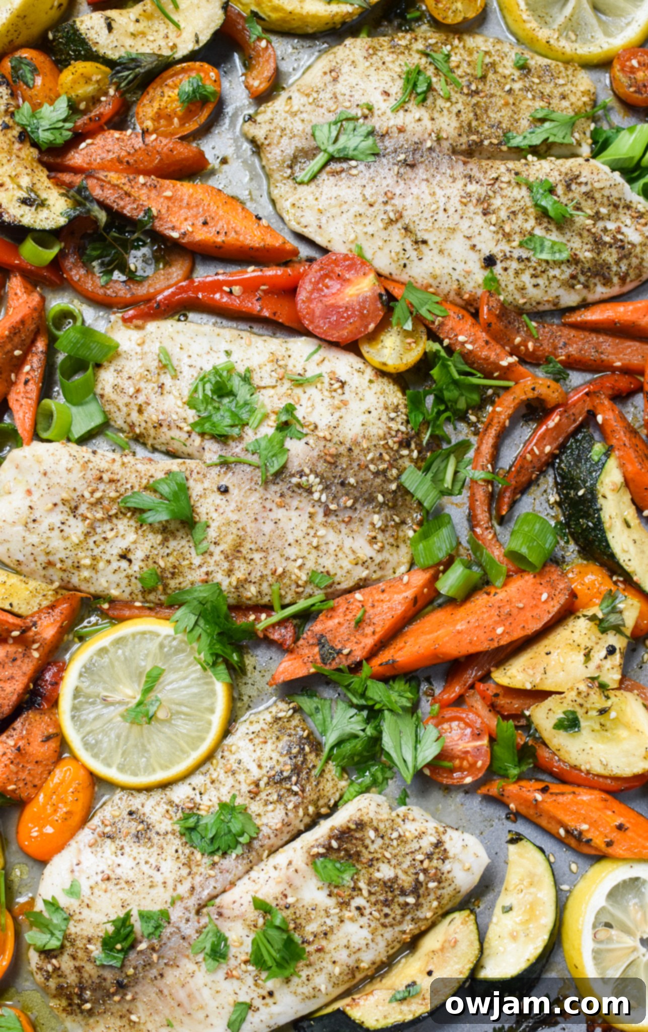 Mediterranean Baked Tilapia with roasted vegetables, lemon slices, and fresh herbs, showcasing a healthy and colorful meal.