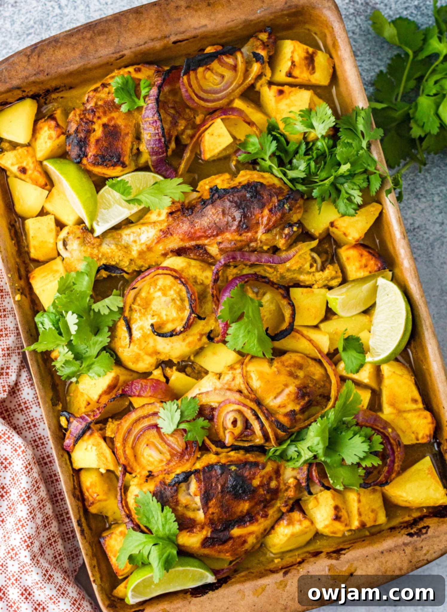 Air Fryer Tandoori Chicken Legs on a baking sheet, garnished with fresh herbs.
