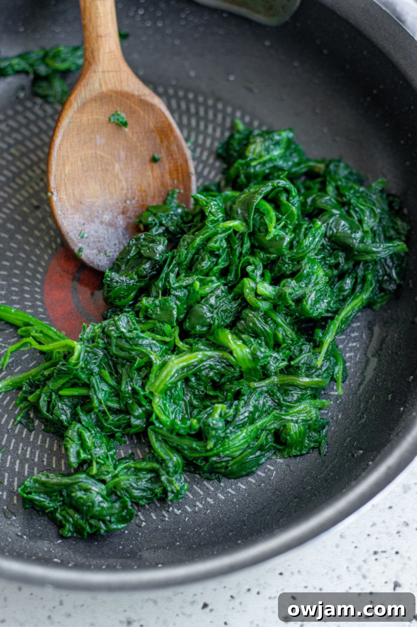 Crispy Spanakopita Pastries 5 Spanakopita Triangles Recipe spinach mixture being sautéed in a pan.