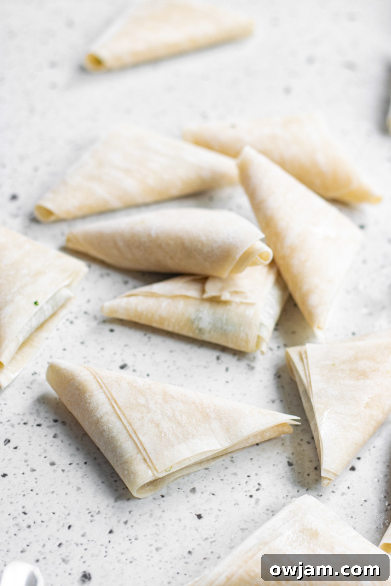 Crispy Spanakopita Pastries 10 Spanakopita Triangles Recipe arranged on a white platter, ready for a party.