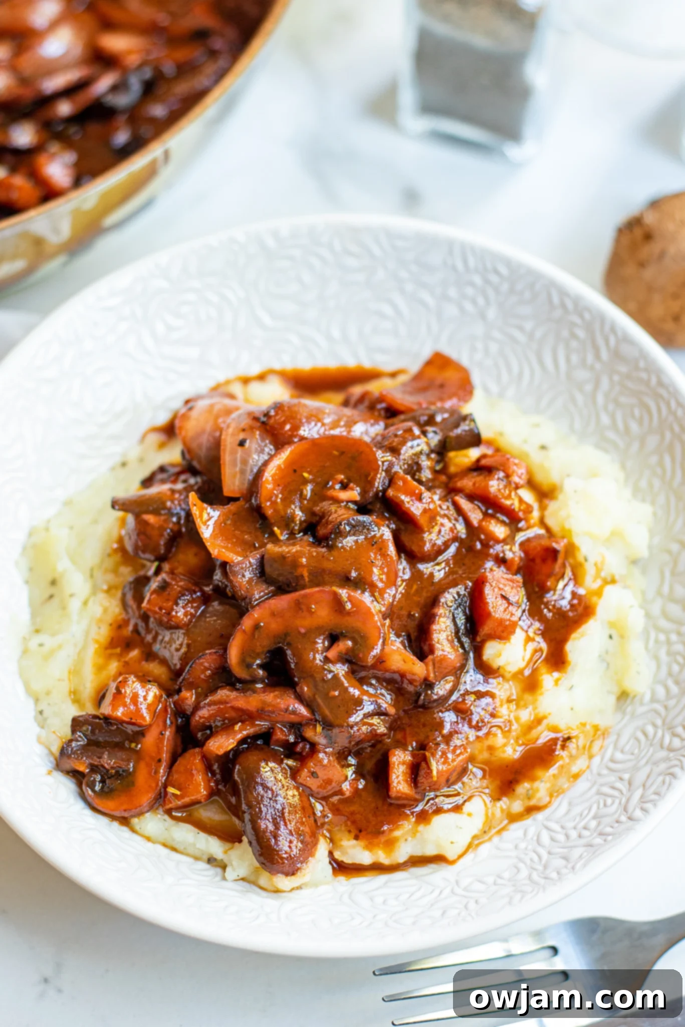 Mushroom Bourguignon on white plate, garnished with fresh parsley.