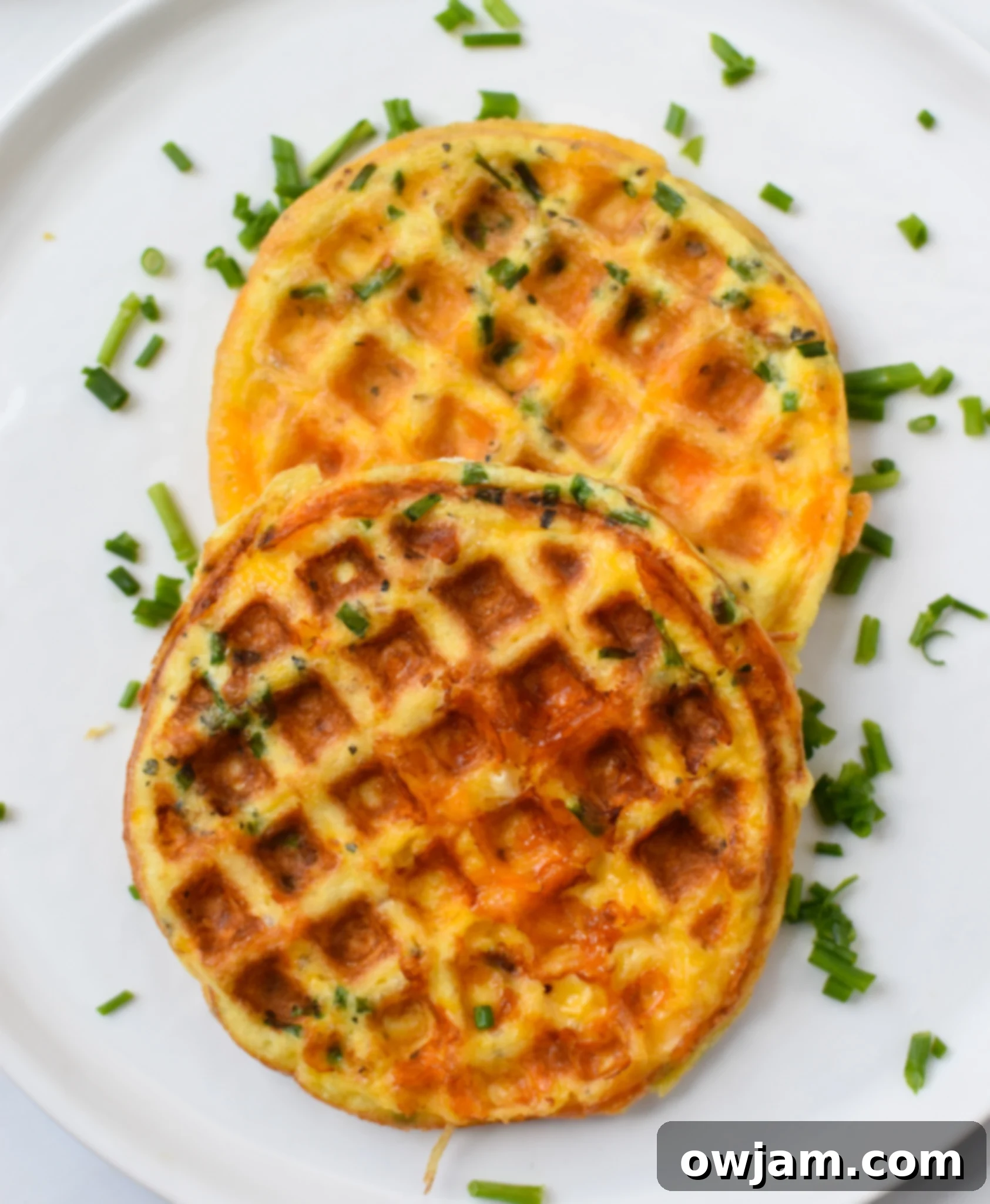 Crispy Chaffles Recipe served on a white plate, garnished with fresh chives.