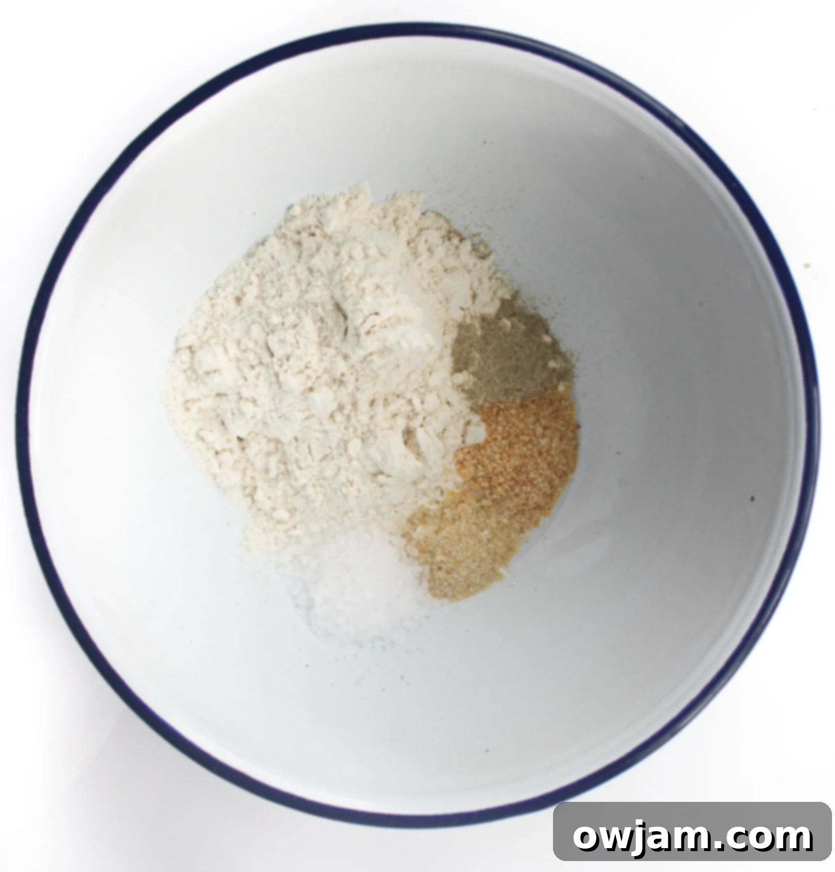 Close-up of a mixing bowl containing the finely mixed flour and spice mixture for air fryer chicken wings, ready for coating.