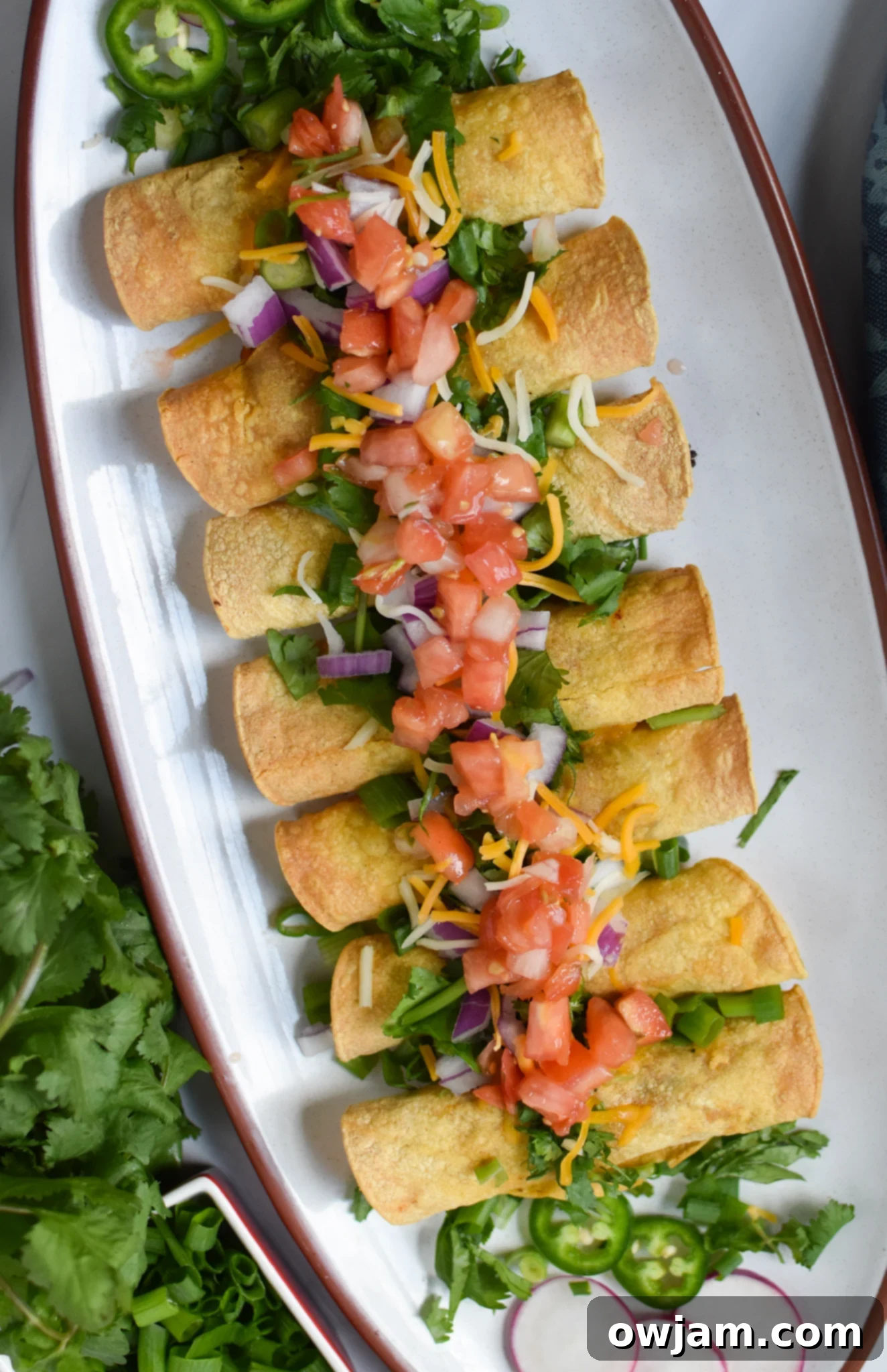 A platter of golden brown Air Fryer Pork Taquitos, perfectly crispy and ready to be served.