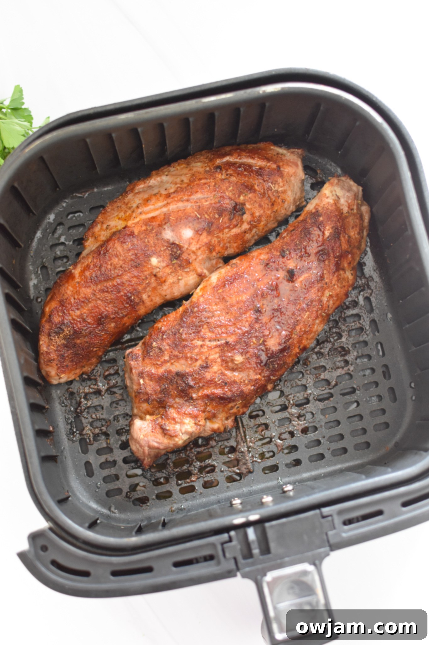 Air Fryer Pork Tenderloin cooking inside the air fryer basket.