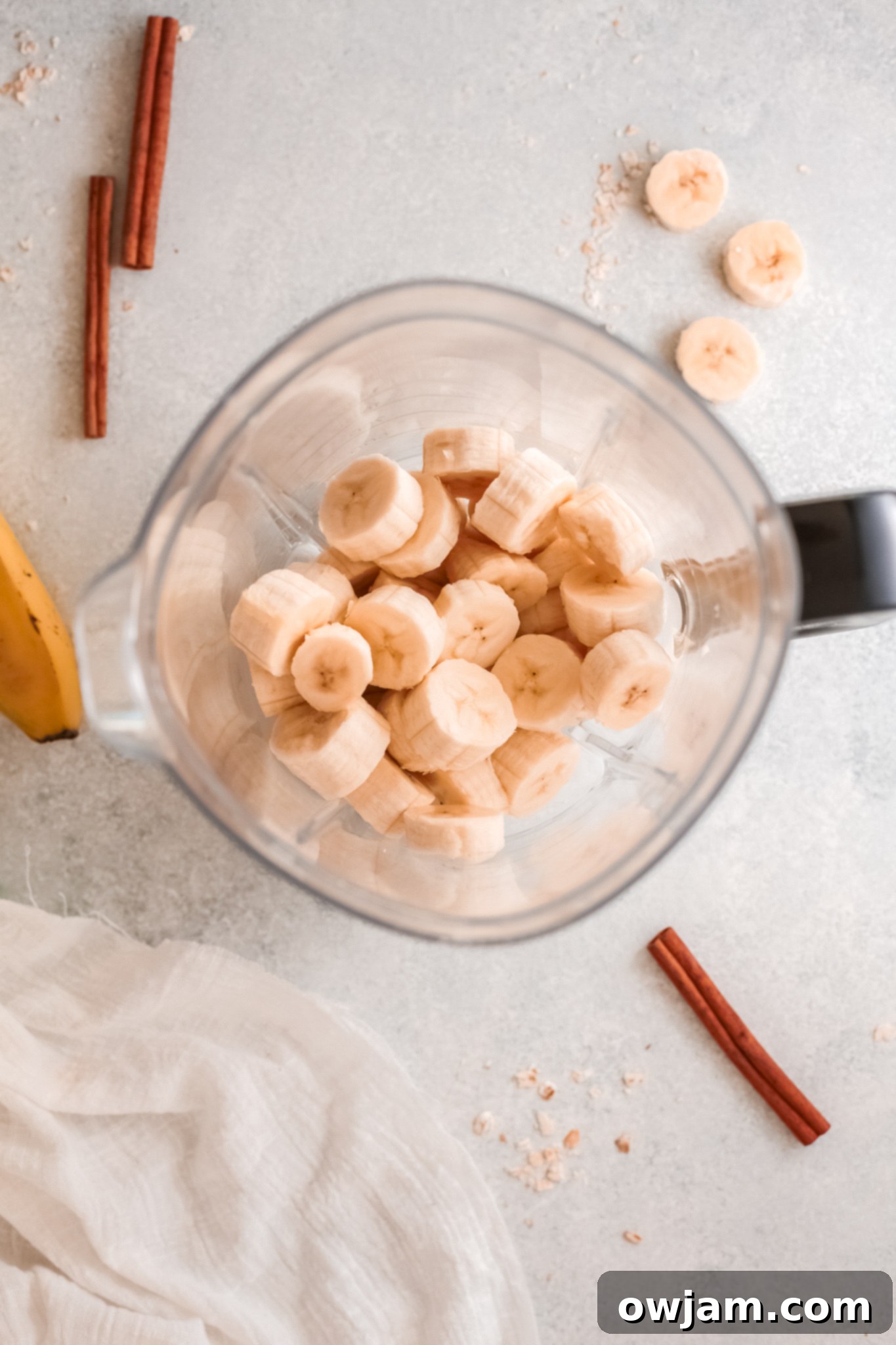 Ripe bananas and other oat smoothie ingredients being added into a high-speed blender.