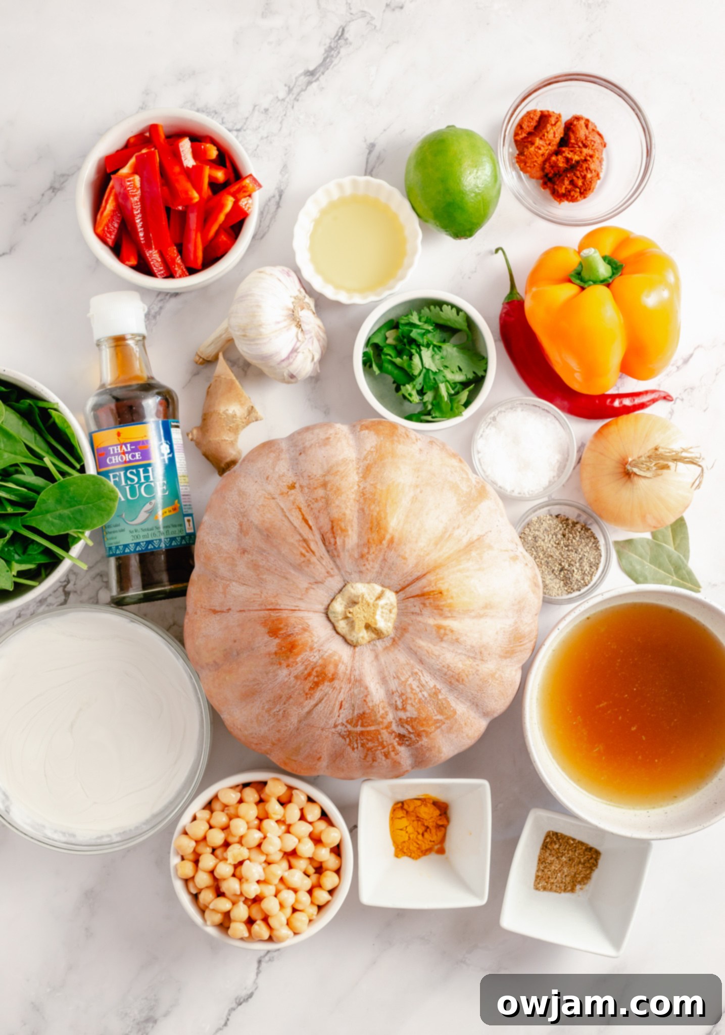A selection of fresh ingredients laid out, including diced pumpkin, bell peppers, spinach, and spices, ready for the Pumpkin Curry Recipe.