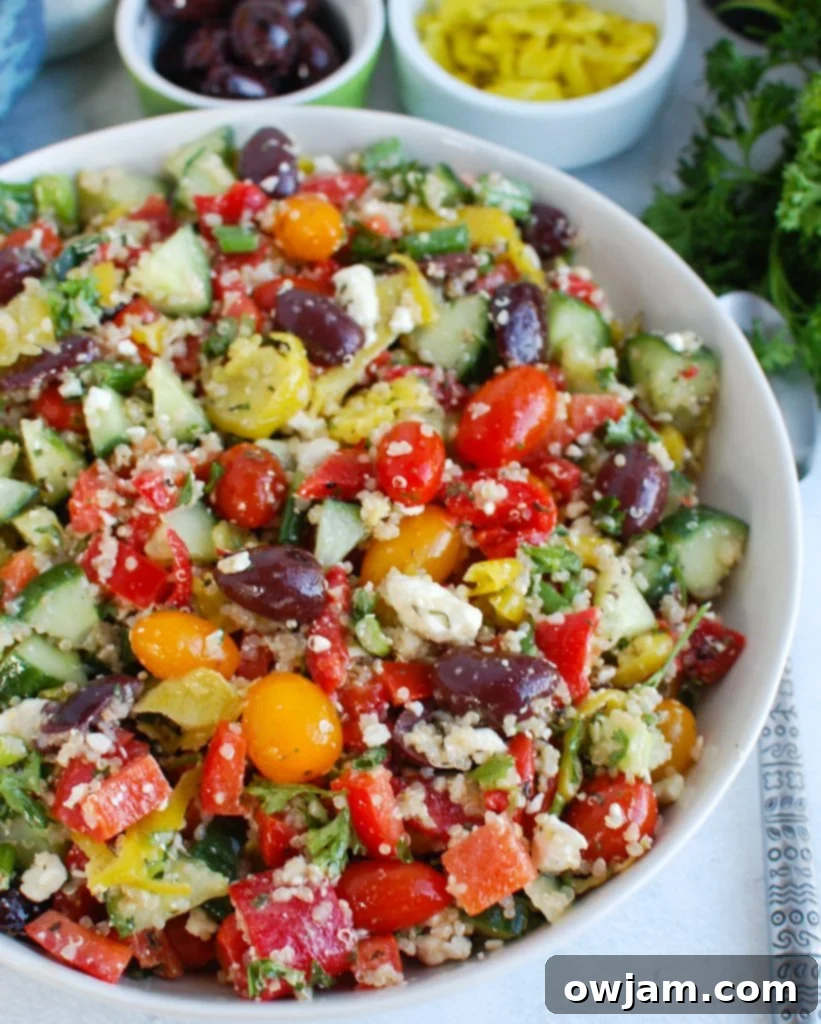 Vibrant Mediterranean Quinoa Salad 2 Vibrant Greek Quinoa Salad in a white ceramic bowl, garnished with fresh herbs and a drizzle of olive oil, ready to be served.