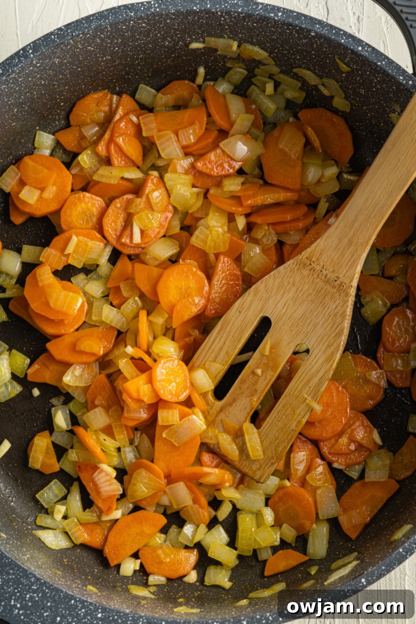 Nourishing Sweet Potato and Lentil Soup 5 Sautéing diced onions, carrots, and celery in a pot as the first step for Sweet Potato Lentil Soup.