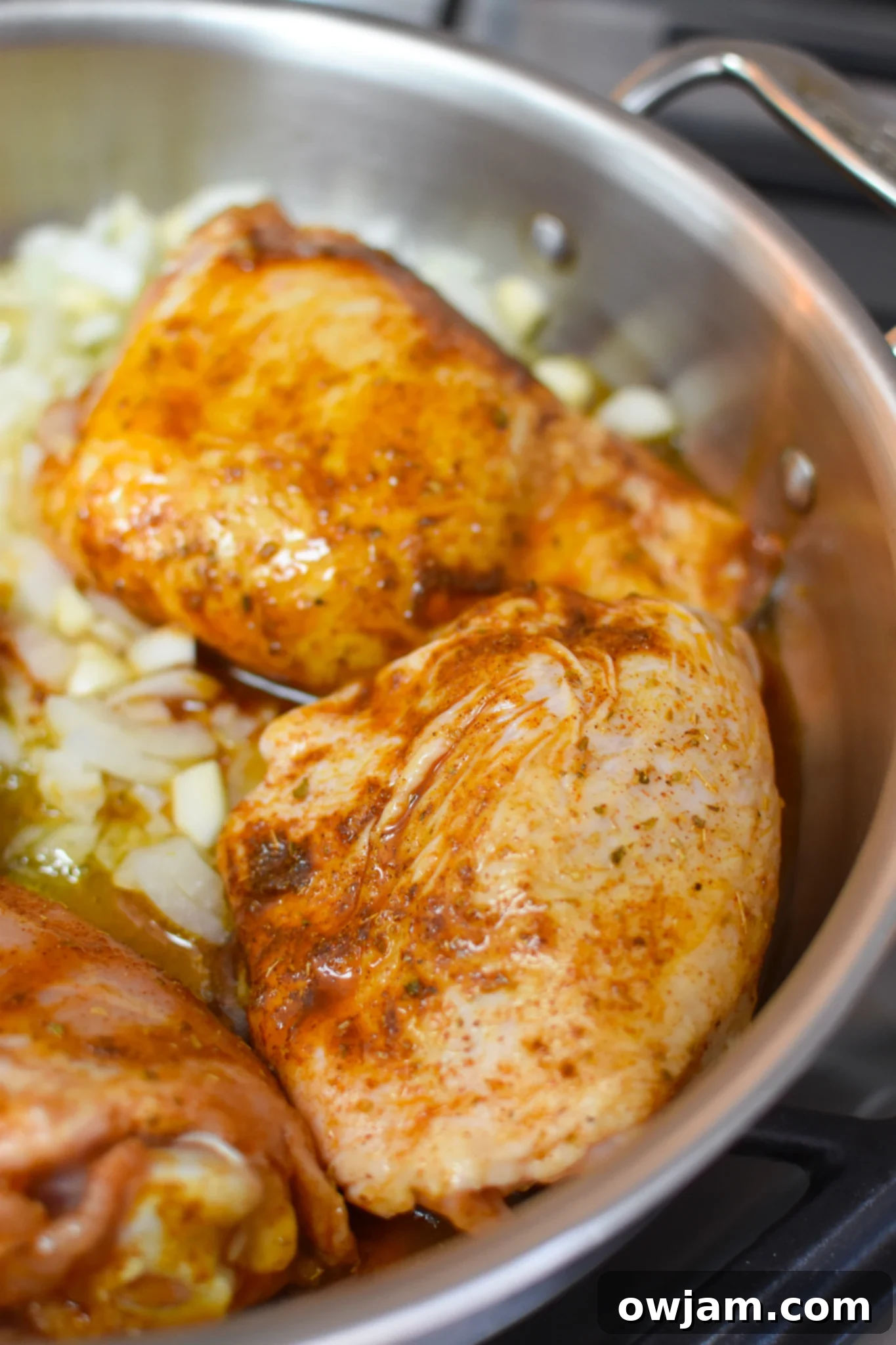 One Pot Mediterranean Chicken and Rice ingredients cooking in a skillet.