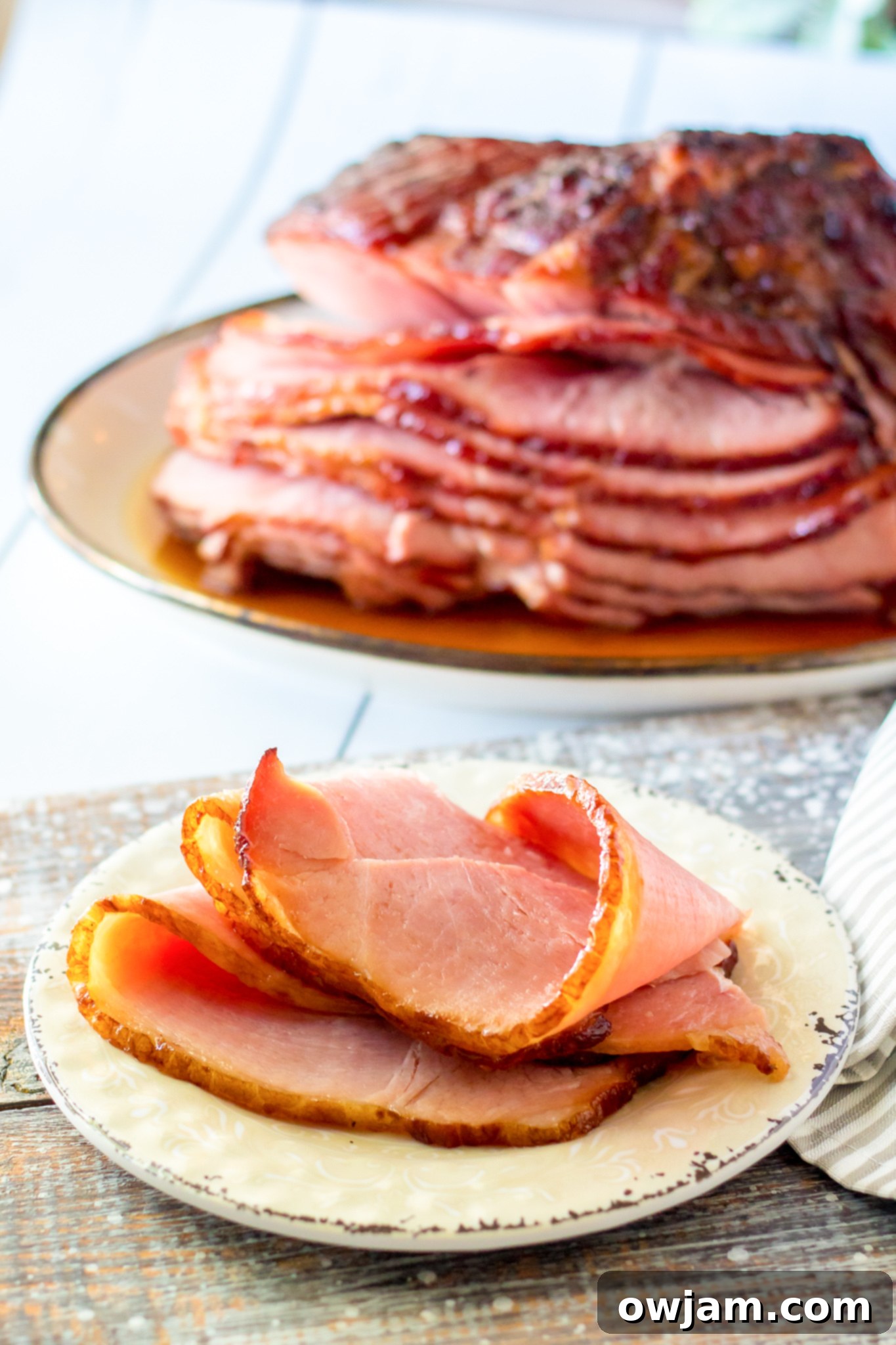 Juicy Apple Cider Glazed Ham Recipe 4 A slice of Apple Cider Glazed Ham served on a white plate, showcasing its juicy interior and caramelized glaze.