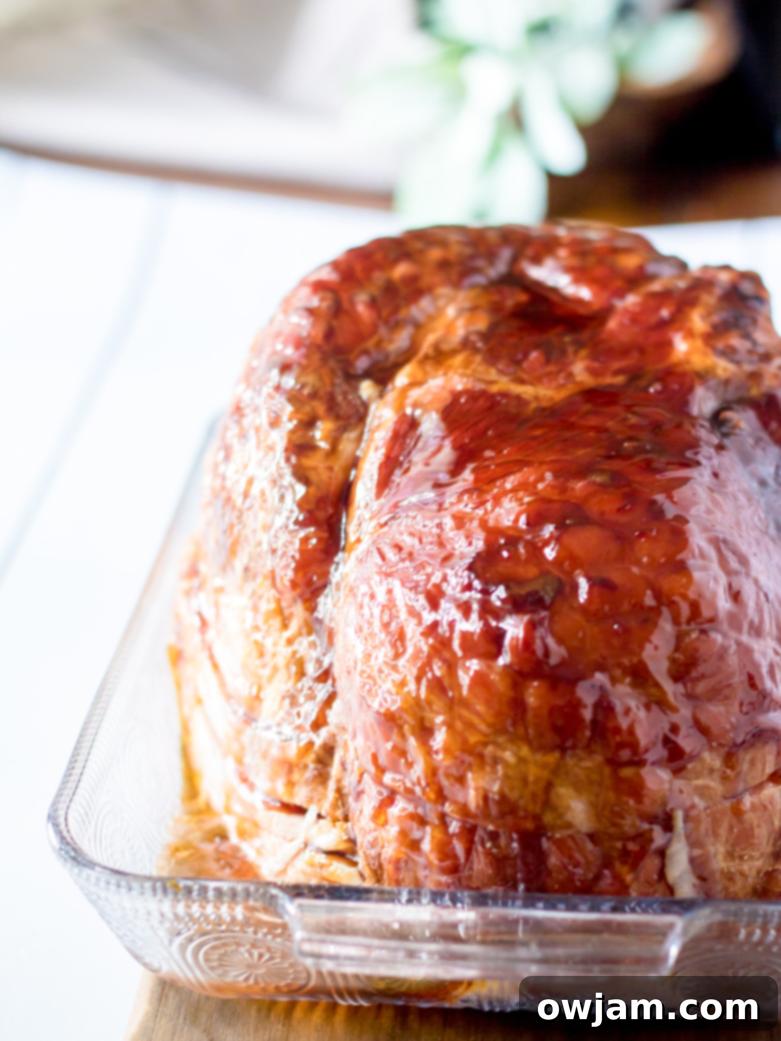 Glazed ham on a cutting board, ready to be sliced and served.