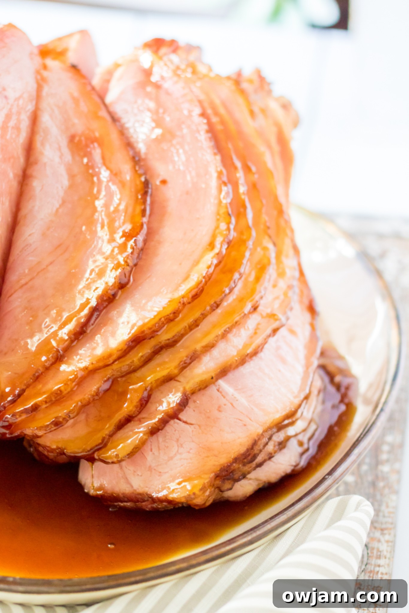 Juicy Apple Cider Glazed Ham Recipe 9 Slices of Apple Cider Glazed Ham arranged on a platter, ready to be served.