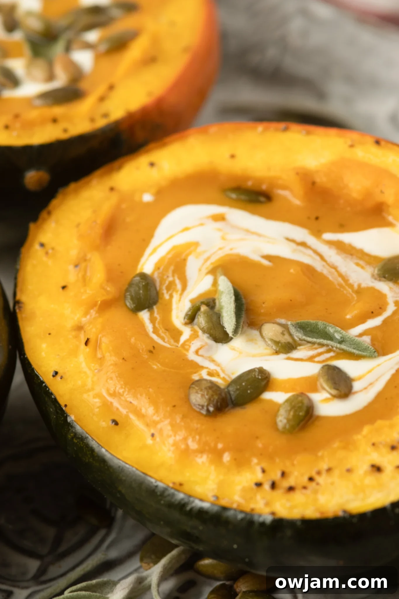 Golden Butternut Sweet Potato Comfort 2 Butternut Squash and Sweet Potato Soup in an acorn squash bowl, garnished with pumpkin seeds and toasted sage.