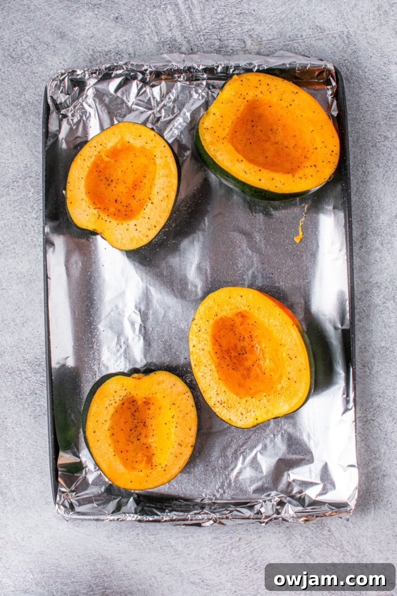 Golden Butternut Sweet Potato Comfort 5 Halved acorn squash on a baking sheet, ready for roasting.