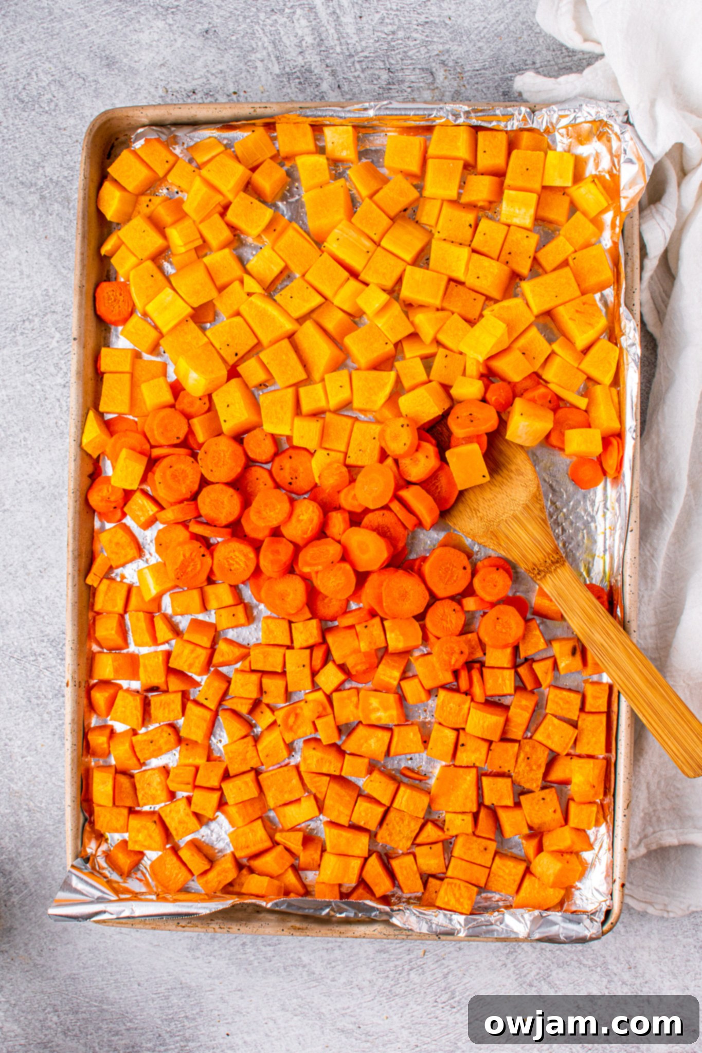 Golden Butternut Sweet Potato Comfort 6 Butternut squash, sweet potato, and carrots on a baking sheet, ready for roasting.