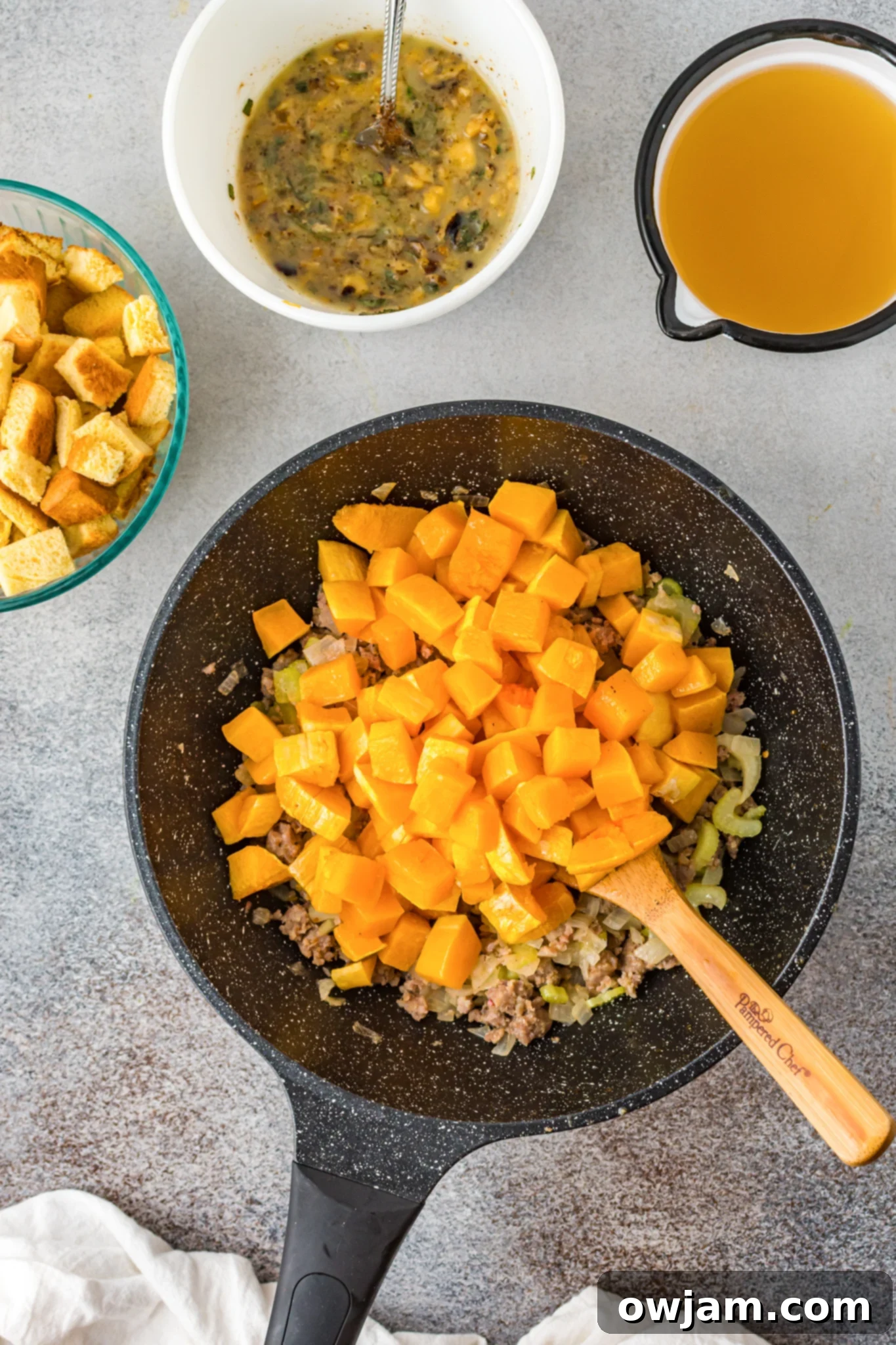 Autumn Butternut Dressing 8 Butternut squash, cooked sausage, and sautéed vegetables combined in a large mixing bowl, forming the savory base of the stuffing.