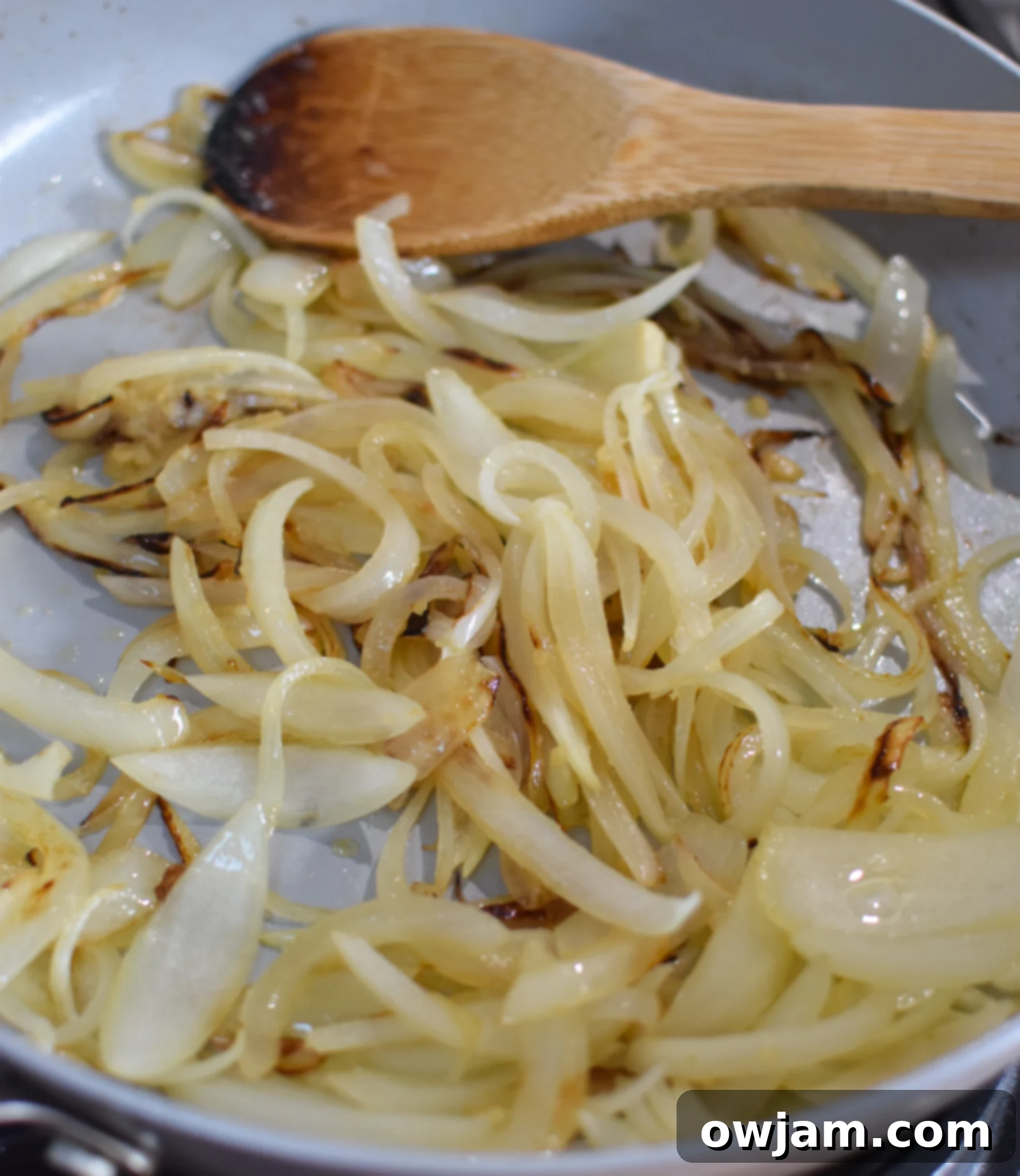 Savory Lebanese Potato and Egg Dish 7 Close-up of thinly sliced onions sautéing in a skillet for Lebanese Potato and Egg Recipe.