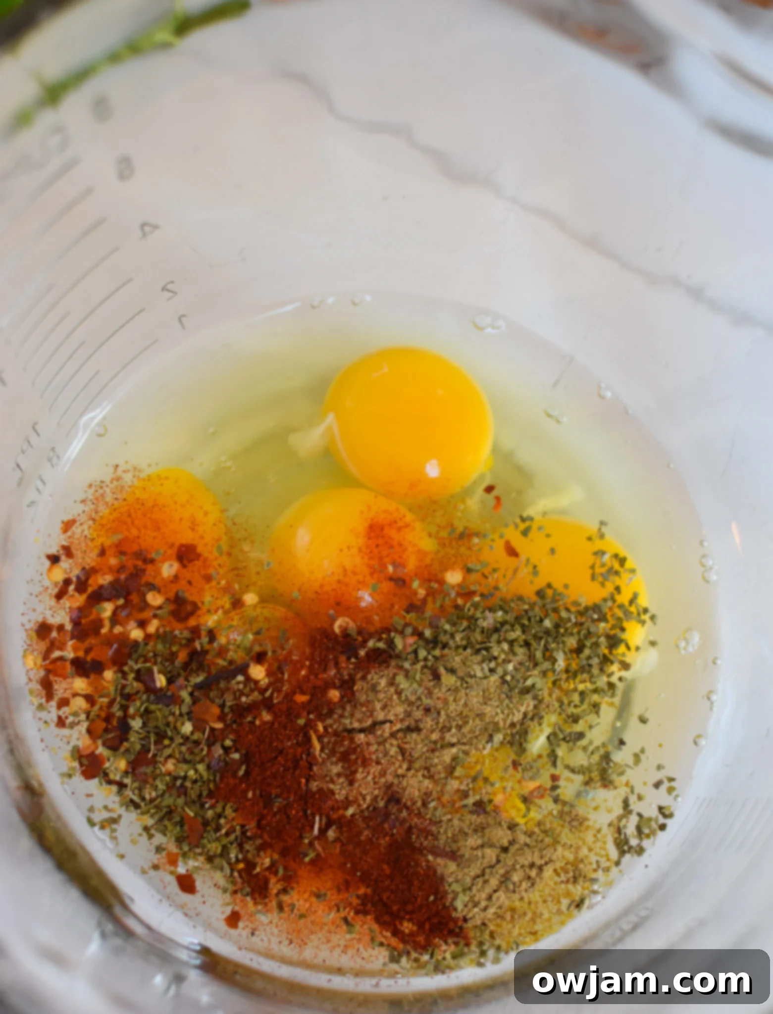 Savory Lebanese Potato and Egg Dish 9 Eggs and spices whisked together in a bowl for the Lebanese Potato and Egg Recipe.