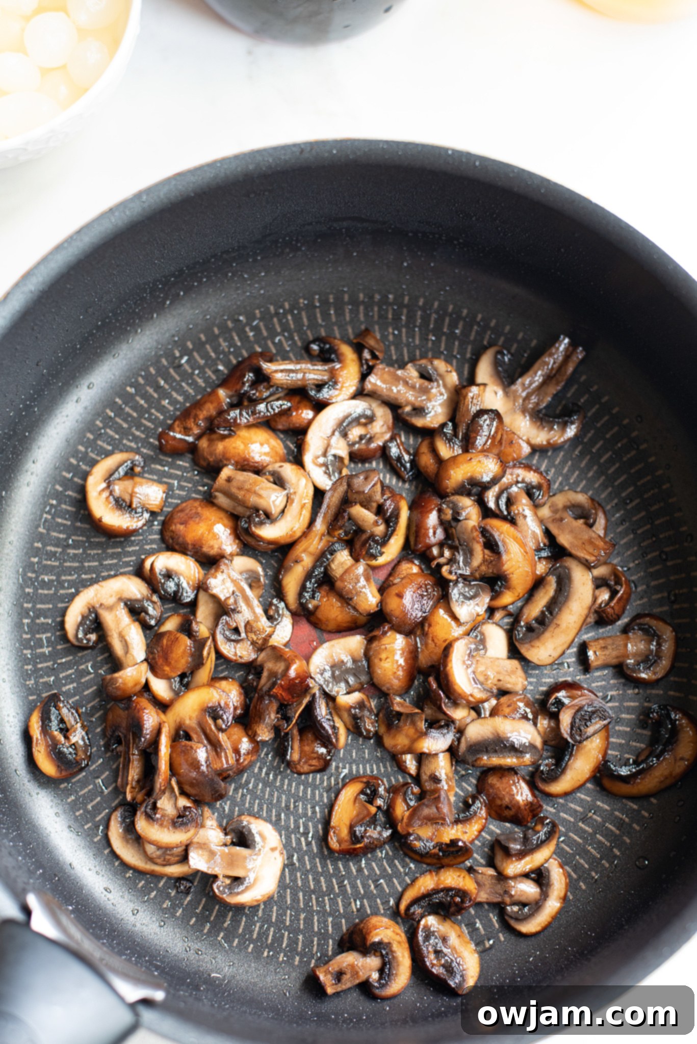 Sautéing mushrooms in a skillet, an essential step for the Coq au Vin Recipe.