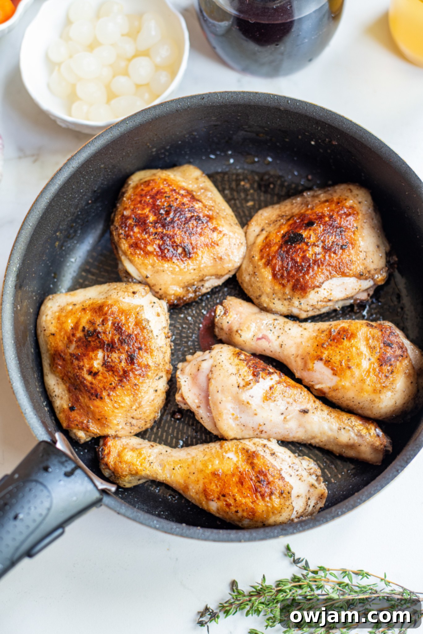Browning chicken in a Dutch oven for Coq au Vin, creating a rich crust.