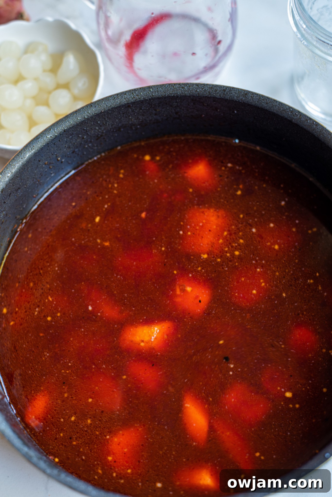 Red wine and onions simmering in a pot, forming the rich sauce for Coq au Vin.