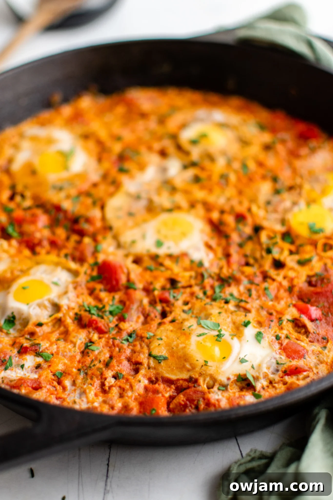 Effortless Shakshuka 2 Easy Shakshuka in a skillet, garnished with fresh herbs.