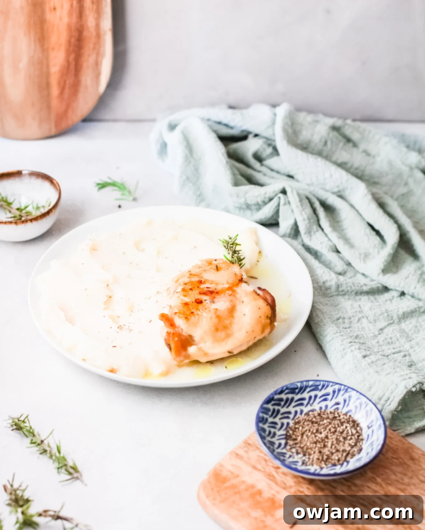 Delicious Instant Pot Creamy Rosemary Chicken 8 Instant Pot Creamy Rosemary Chicken on a plate with a blue napkin.