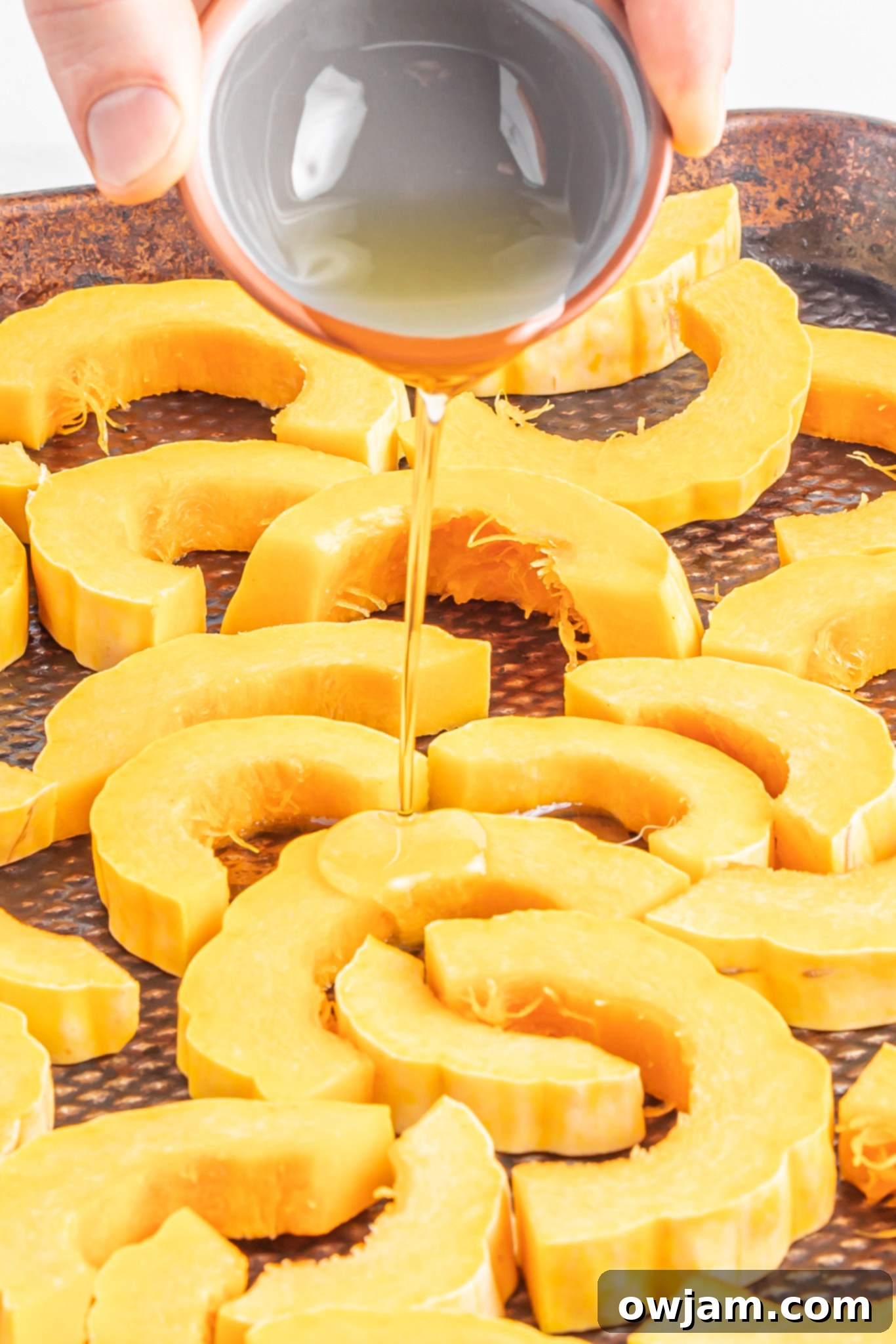 Za'atar Roasted Delicata Squash slices being spread out on a baking sheet before roasting.