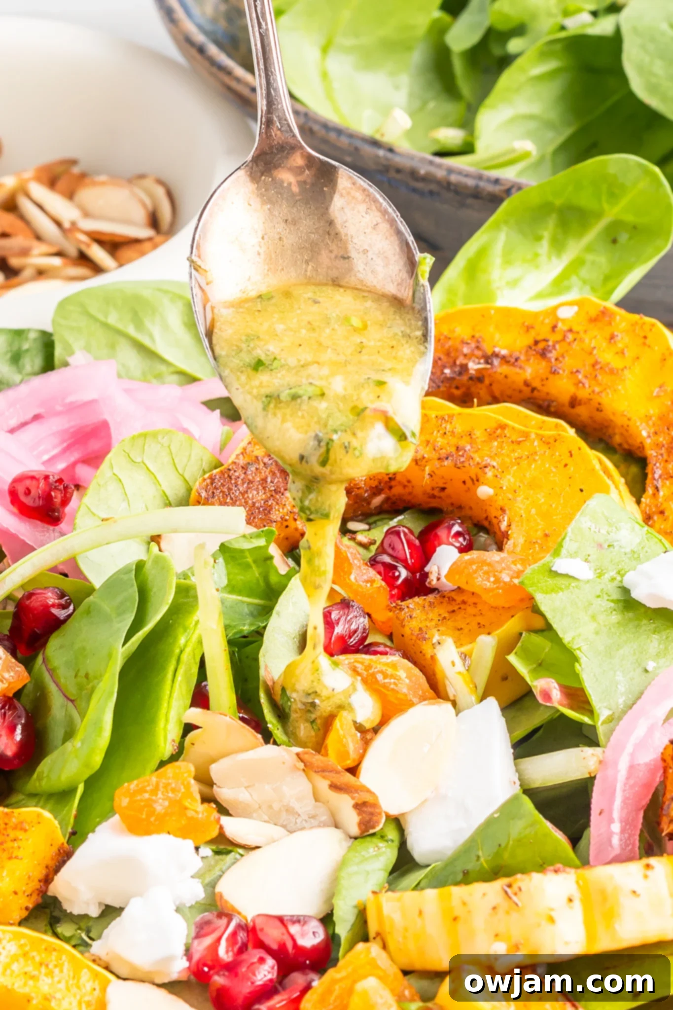Za'atar Roasted Delicata Squash salad being drizzled with homemade dressing.