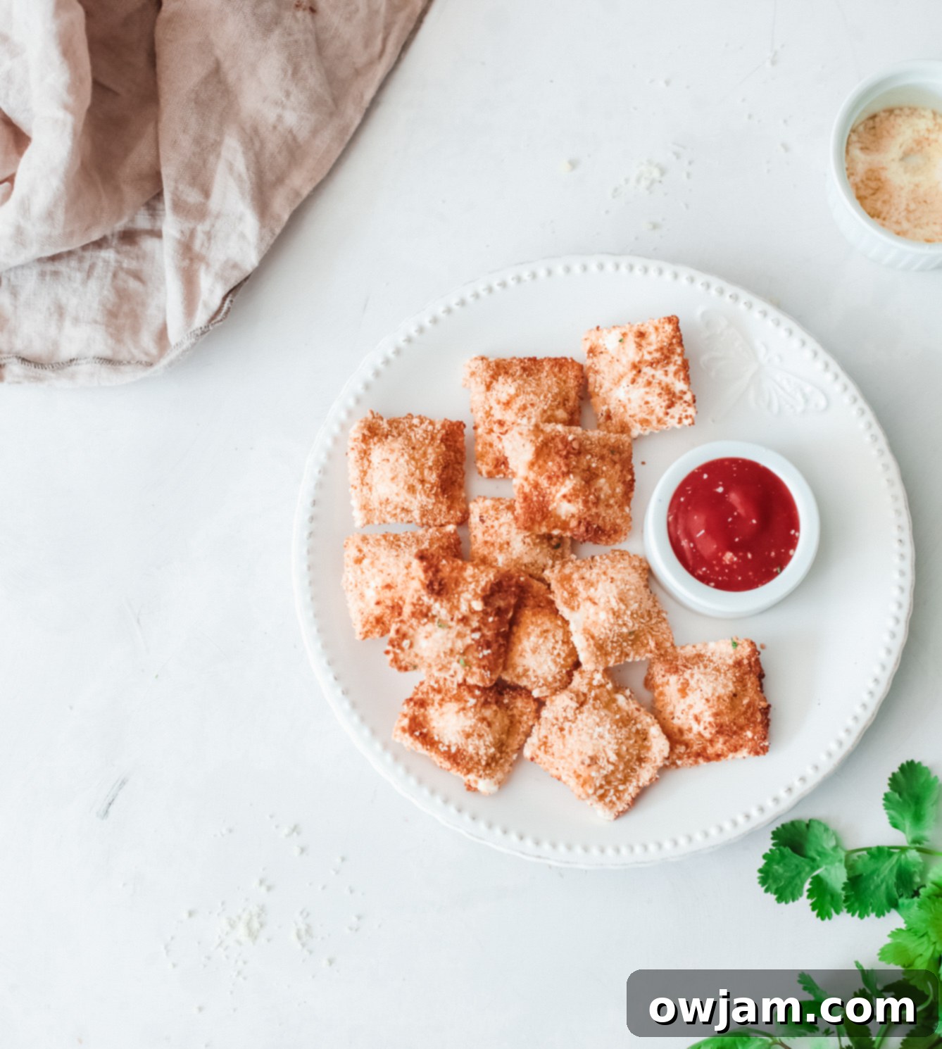 Air Fried Ravioli garnished with fresh parsley on a plate, with a napkin.
