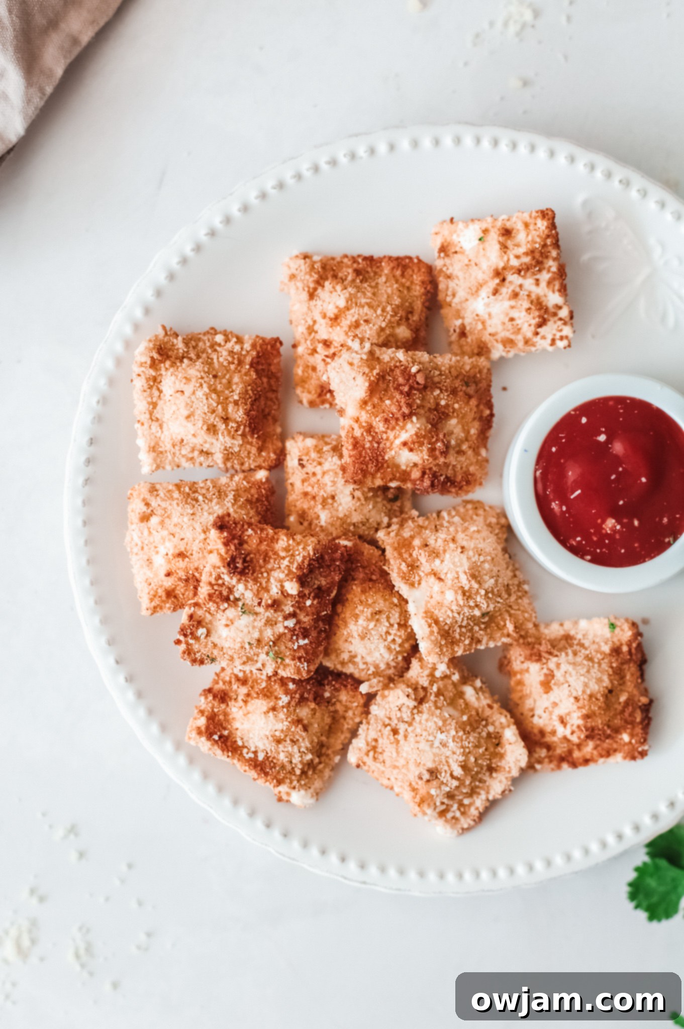 Air Fried Ravioli with a side of red sauce in a small bowl.