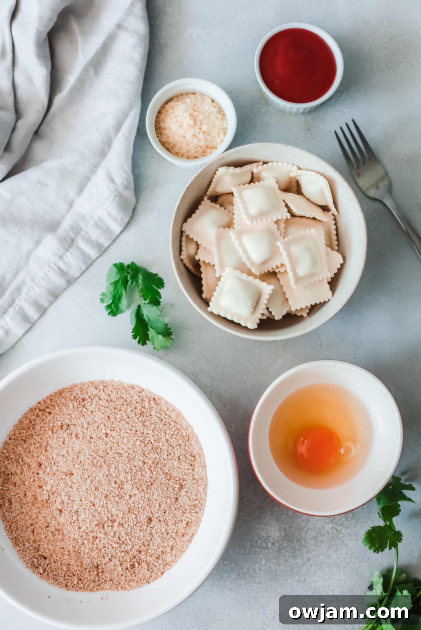 Ingredients laid out for Air Fried Ravioli, including fresh ravioli, eggs, breadcrumbs, and cheese.