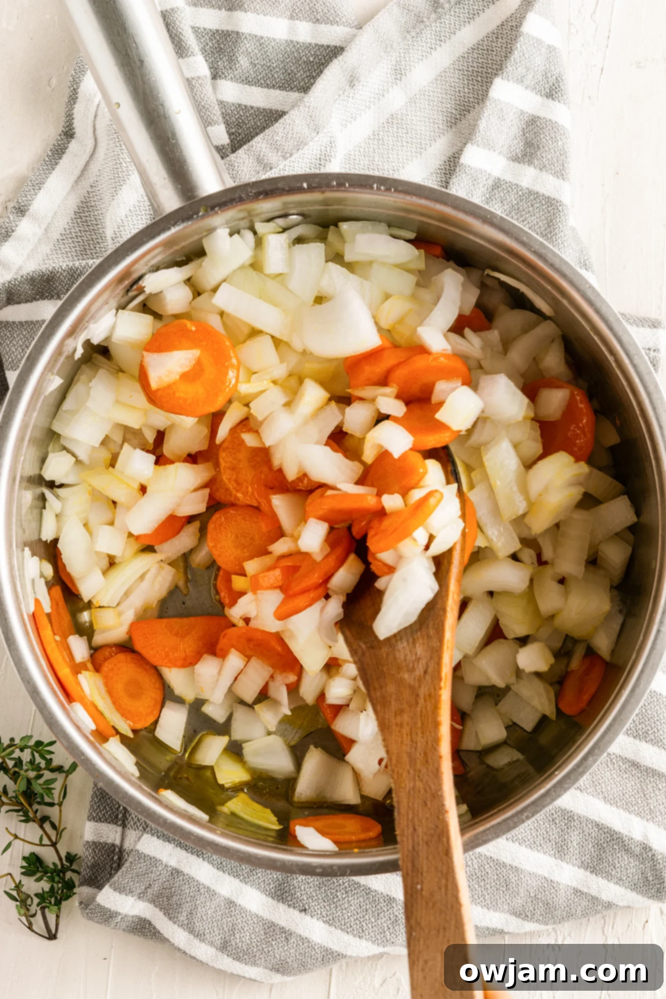 Lentil Mushroom Stew with onions, carrots, and garlic sautéing in a pot.