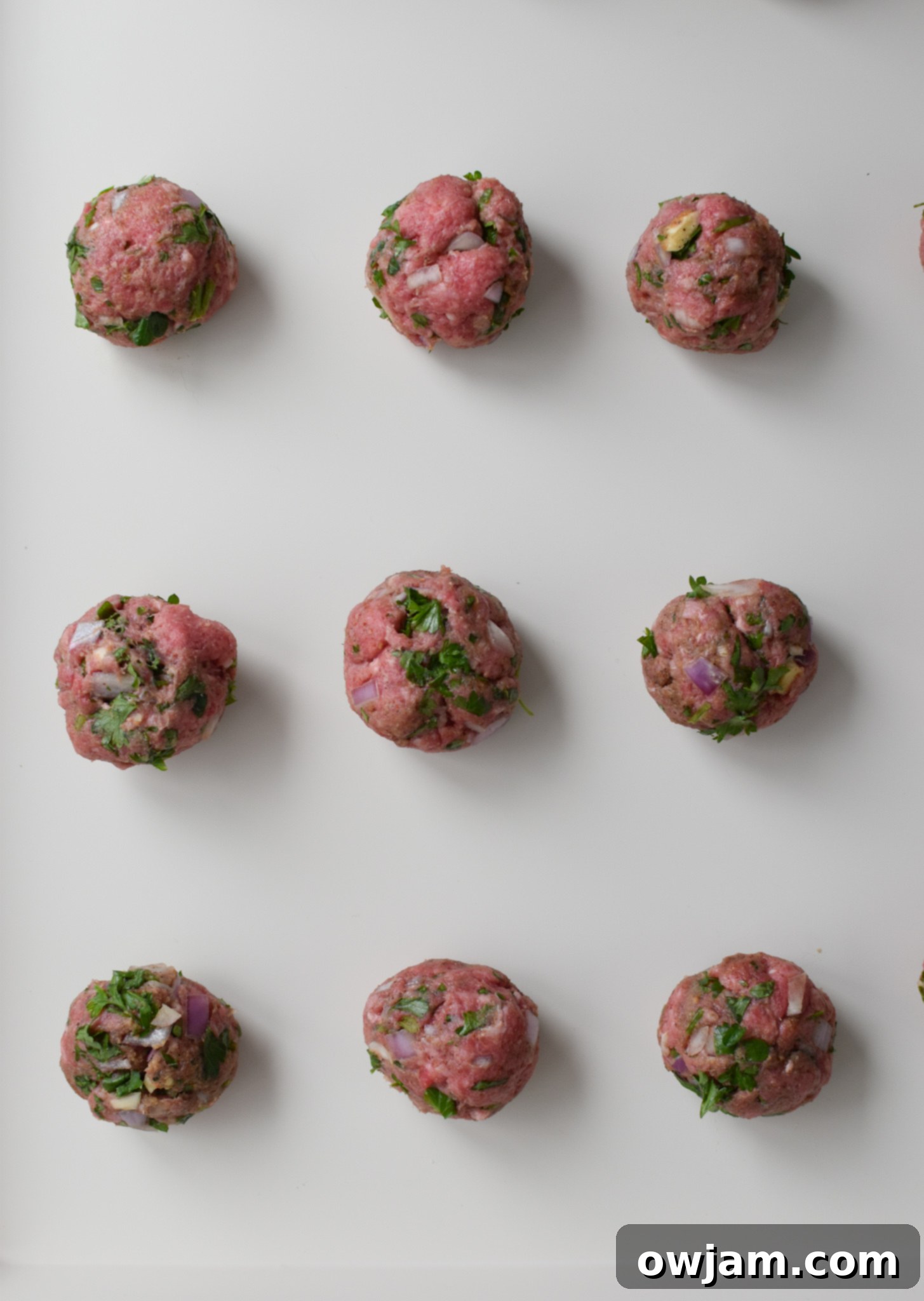 Mediterranean Baked Beef Meatballs meatballs on a baking sheet.