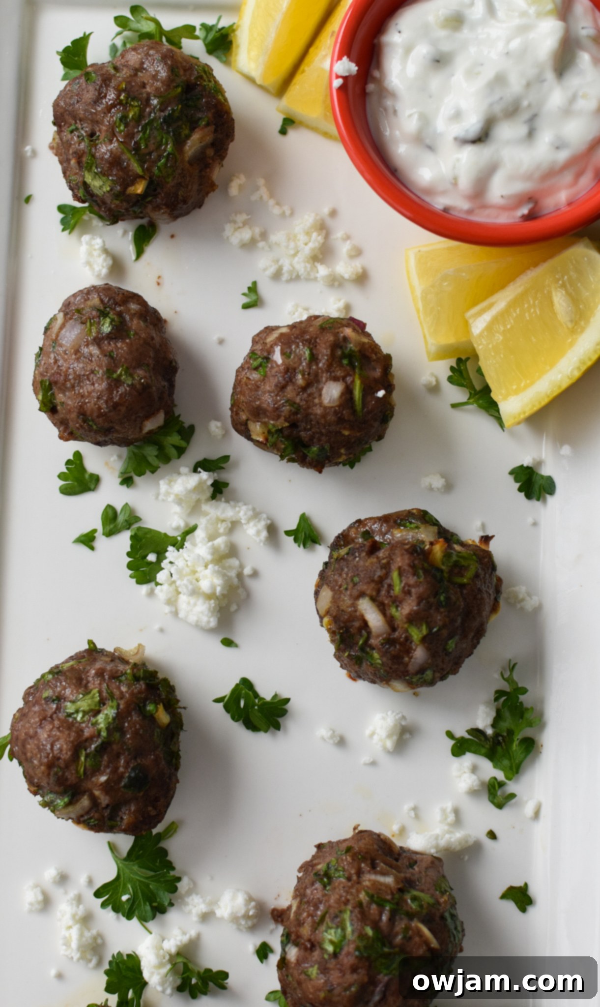 Mediterranean Baked Beef Meatballs on a white platter.