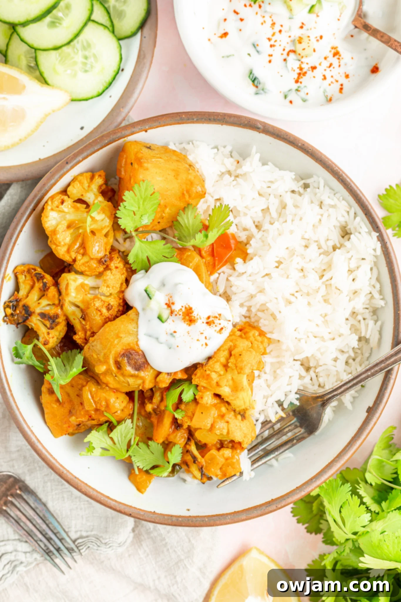 Creamy Cauliflower Curry with Potatoes and fresh cilantro garnish in a white bowl.