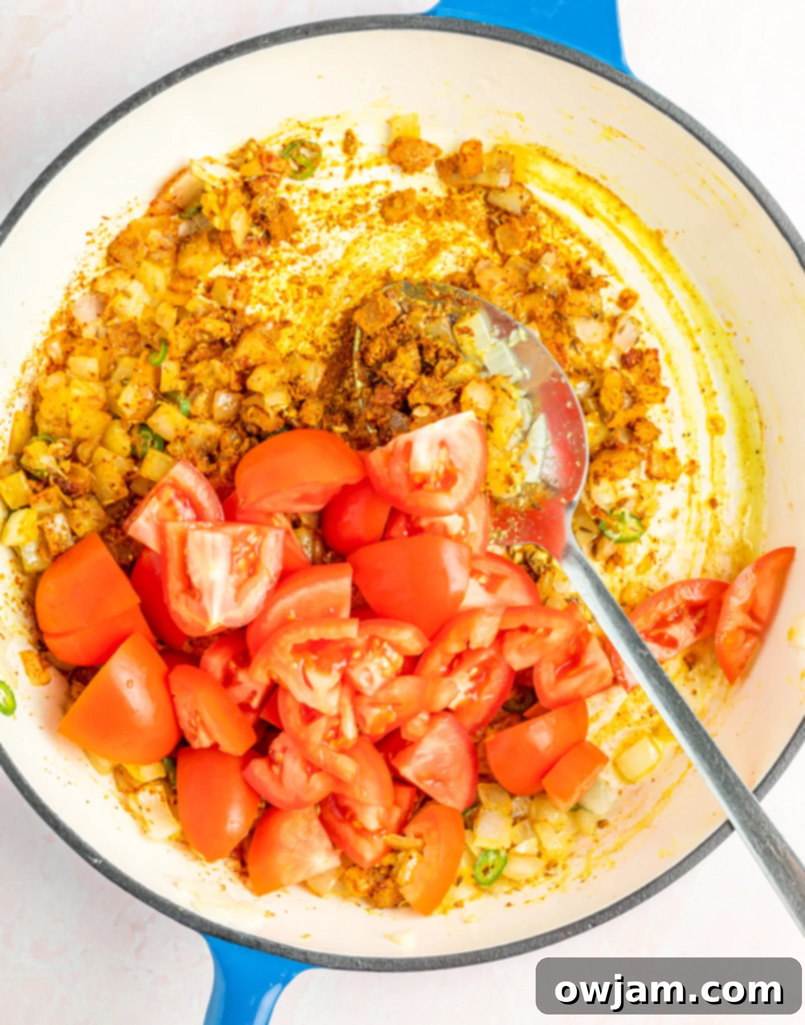 Golden Cauliflower Curry 7 Vibrant tomato-based curry sauce simmering in a deep skillet, ready for vegetables.