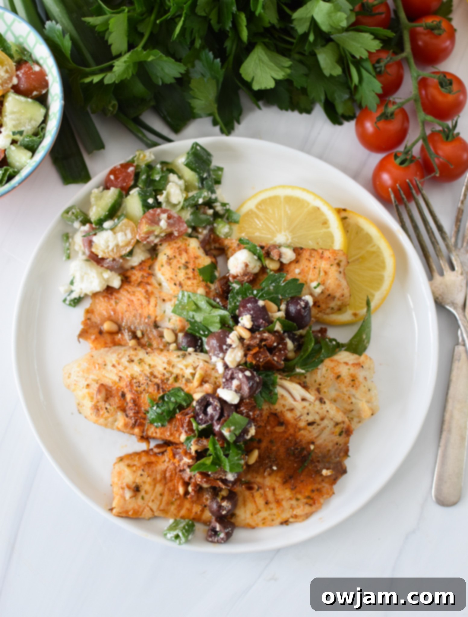 Greek Baked Tilapia with olives and a salad.
