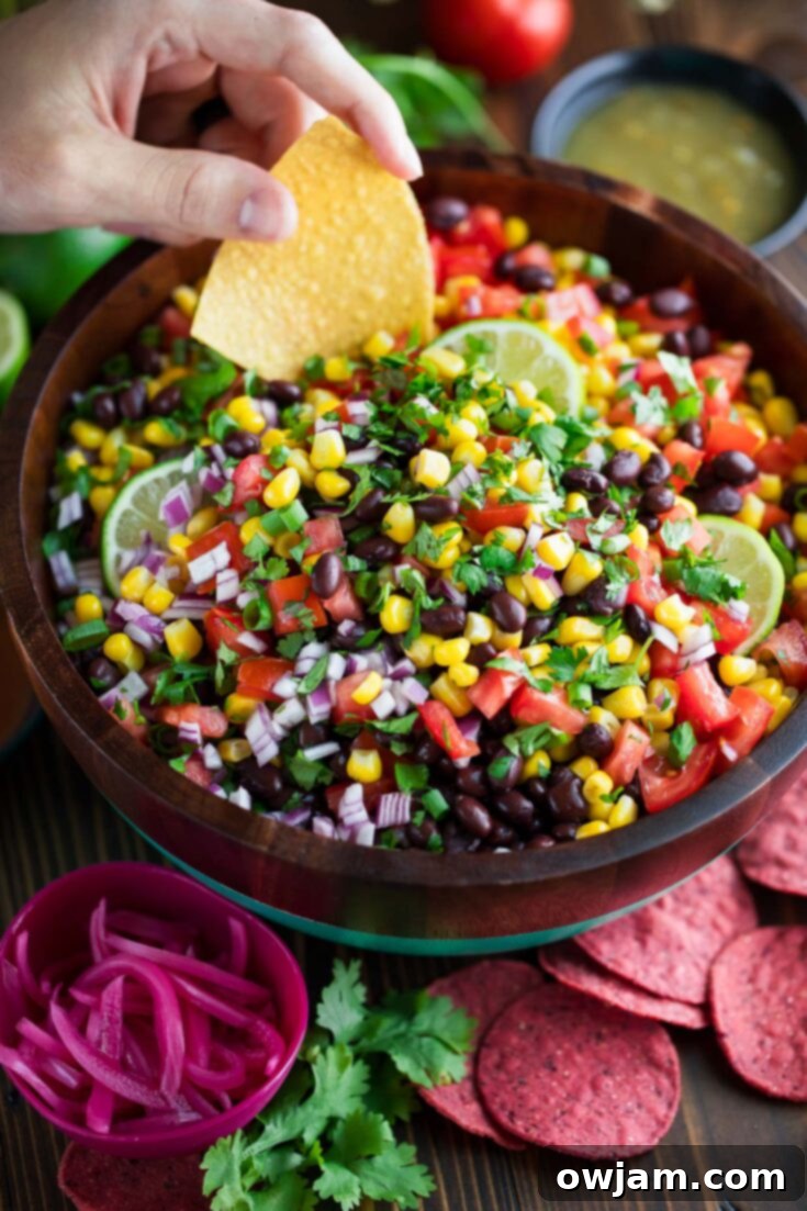 23 Irresistible Sides to Elevate Your Taco Night 16 A bowl of vibrant Black Bean Salsa, packed with black beans, corn, tomatoes, red onion, and cilantro, perfect for dipping or as a topping.